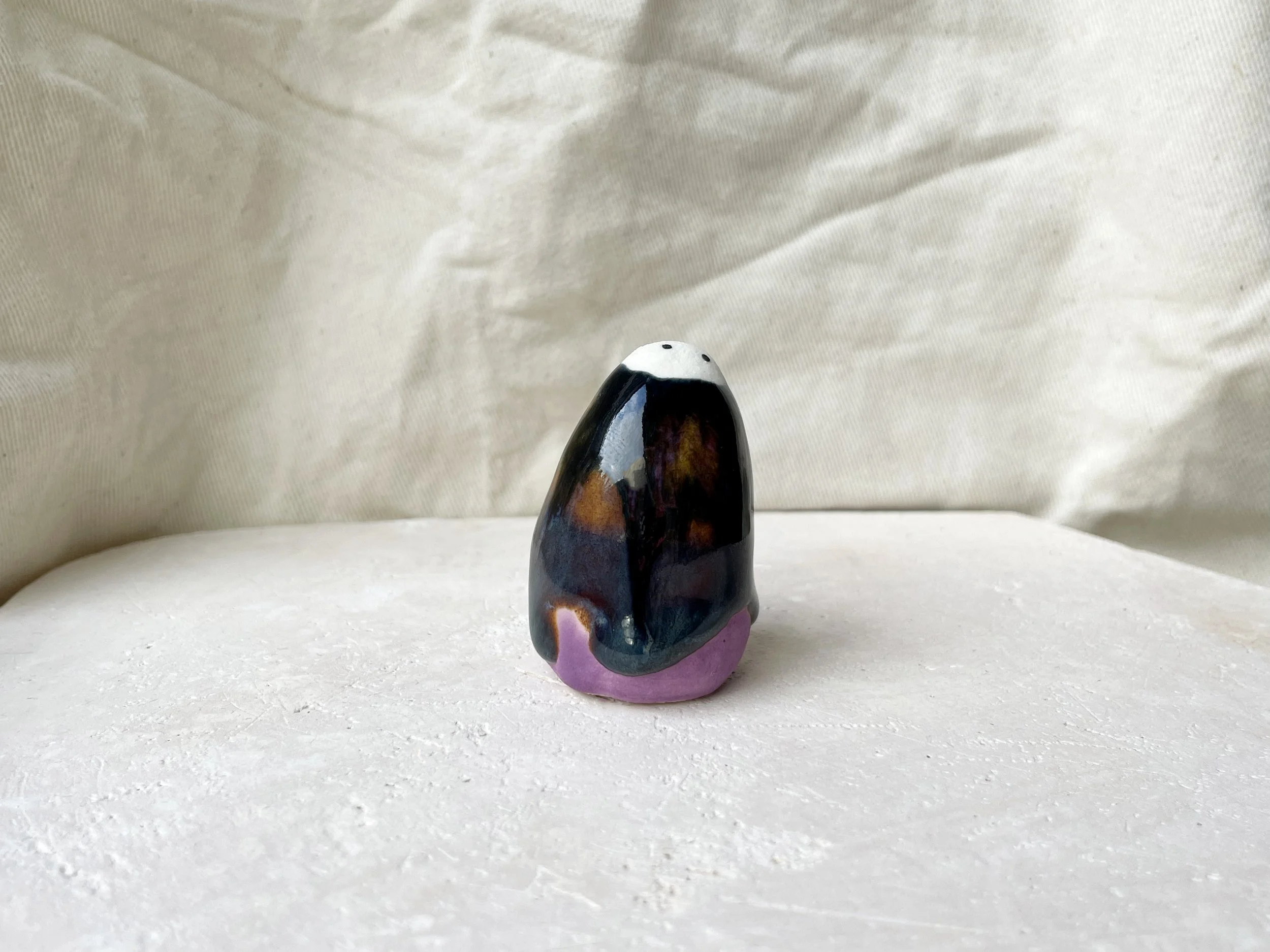 Purple, black, orange, blue handmade figurative ceramic sculpture with underglaze and drippy runny glaze
