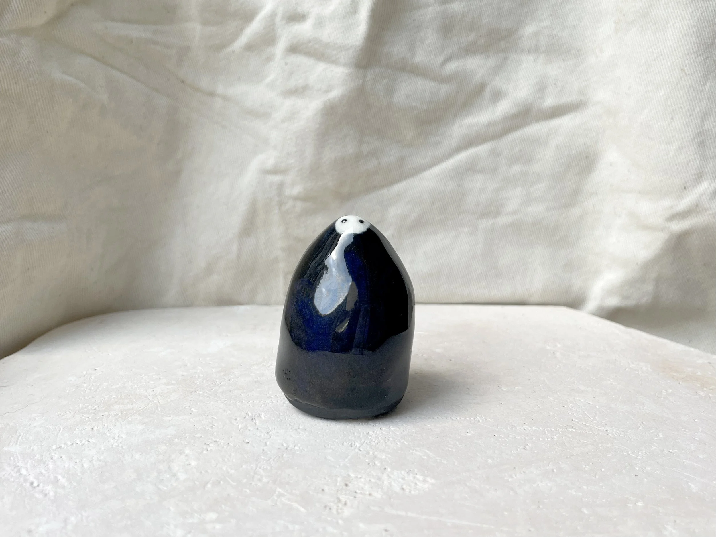 Black and blue handmade figurative ceramic sculpture with glossy floating glaze