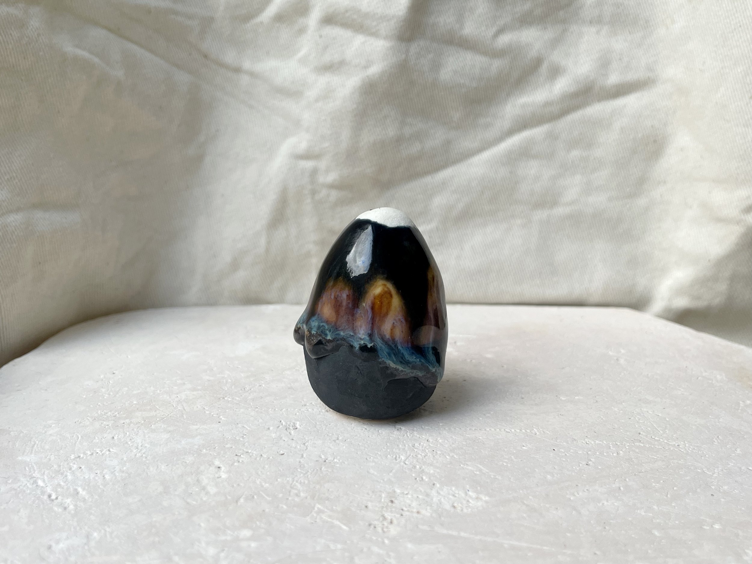 Black, orange and blue handmade figurative ceramic sculpture with underglaze and drippy float glaze