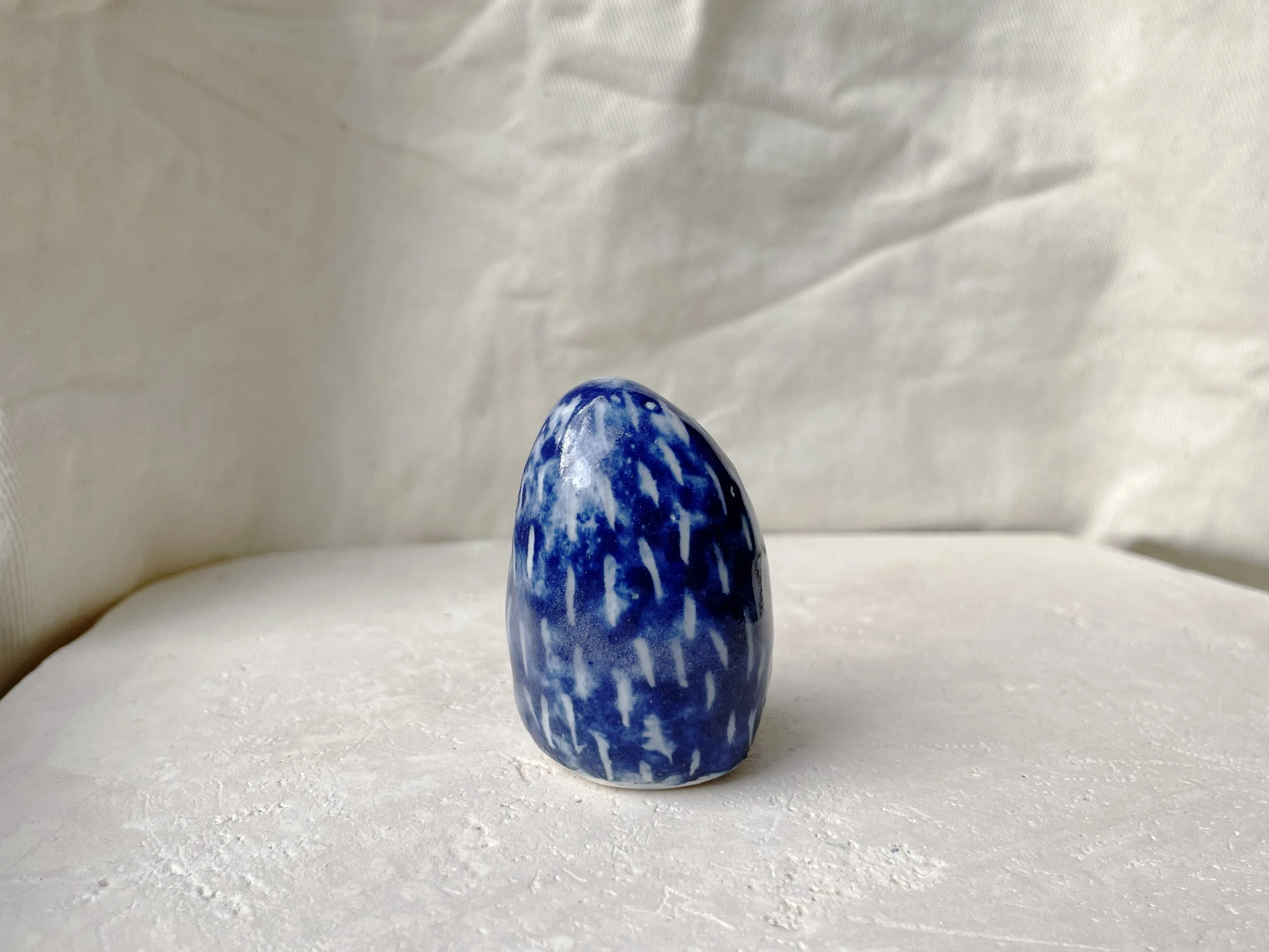 blue and white handmade figurative ceramic sculpture with cobalt oxide and glaze