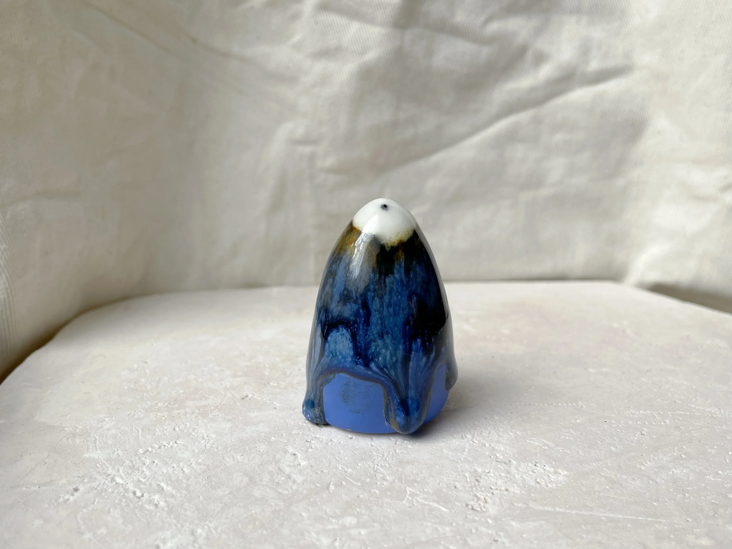 Blue, yellow, black handmade figurative ceramic sculpture with glossy runny floating glaze