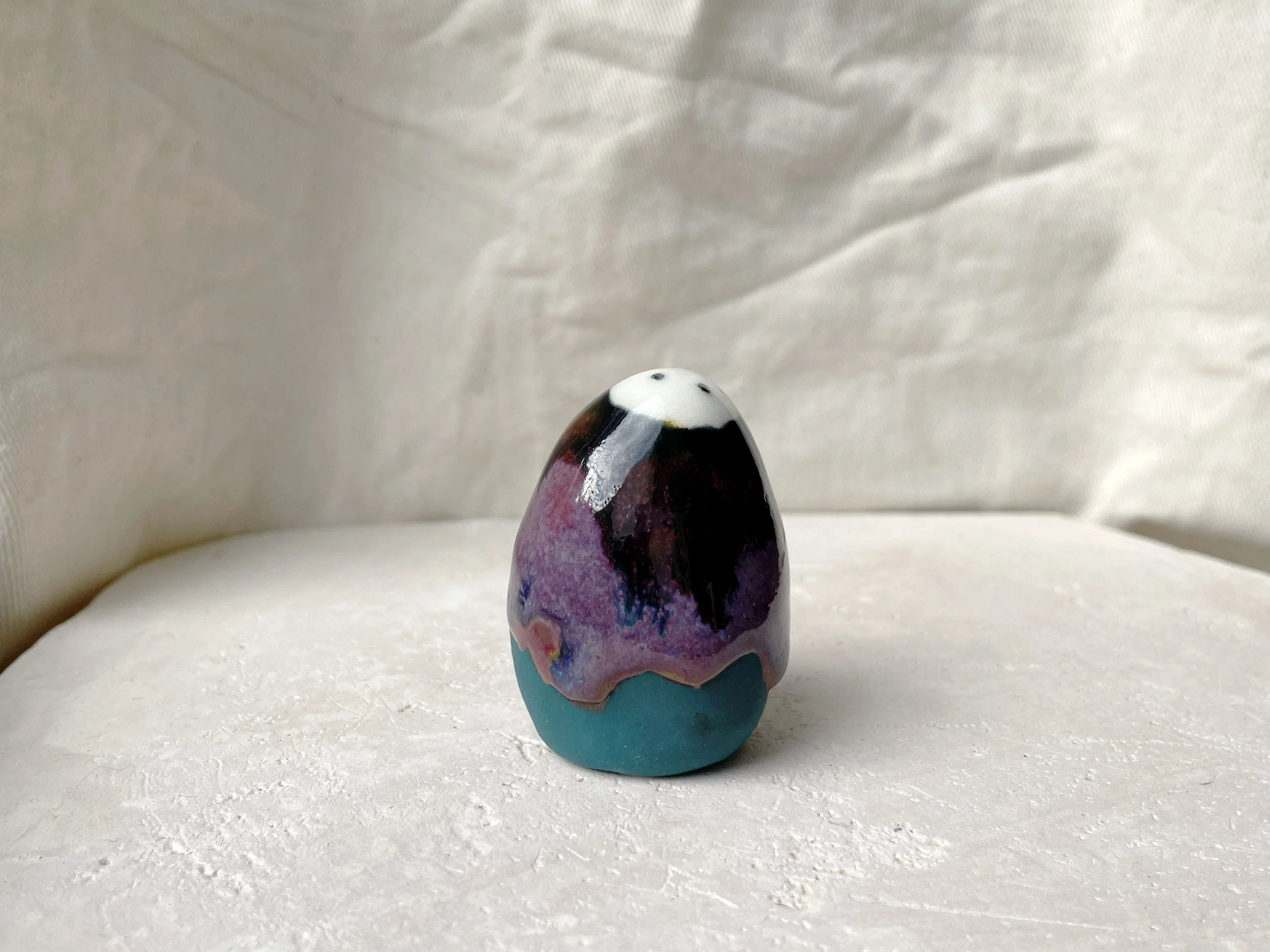 Black, purple, green and red handmade figurative ceramic sculpture with glossy drippy floating glaze