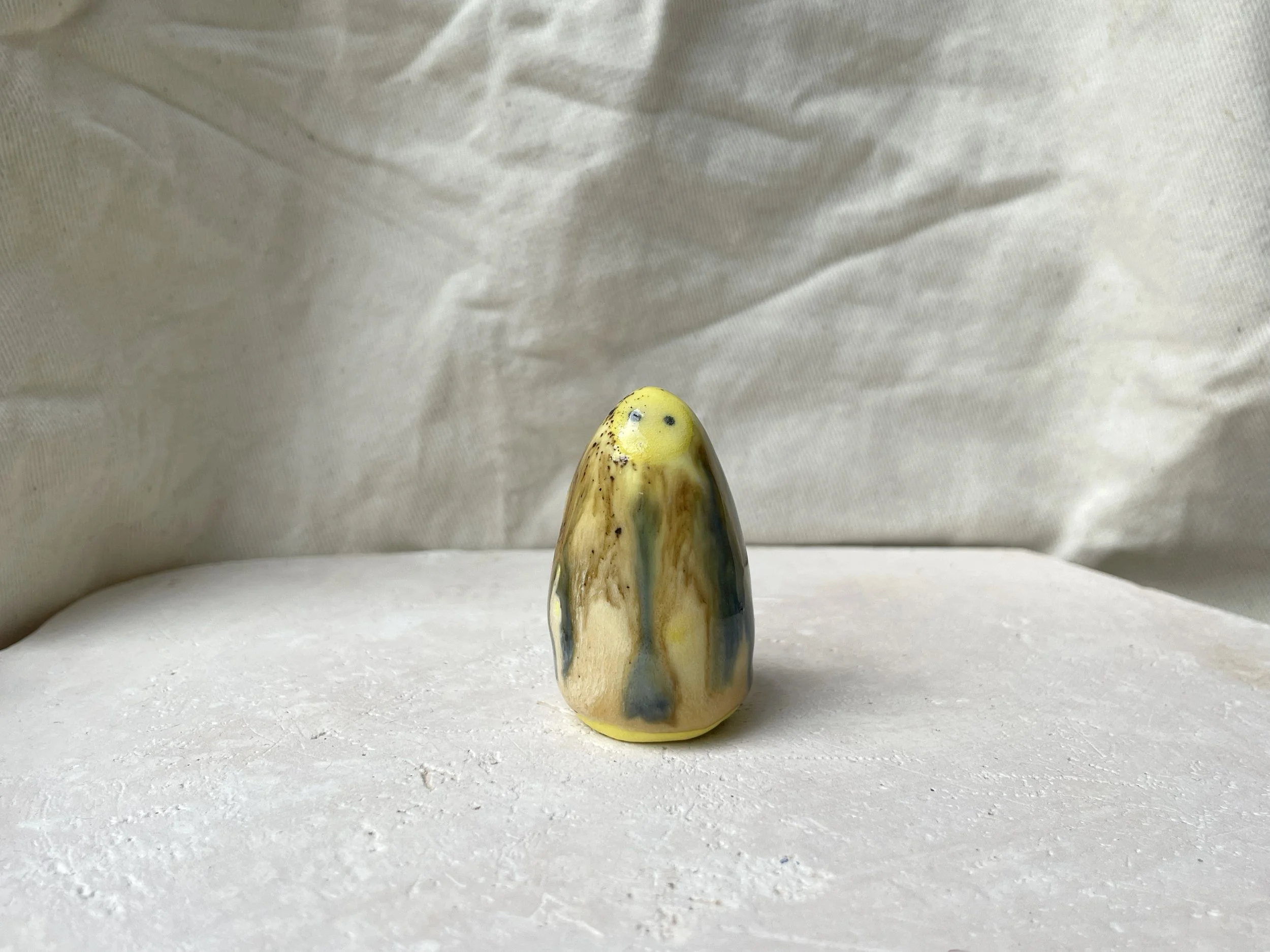 Yellow, blue and brown handmade figurative ceramic sculpture with underglaze and runny glaze