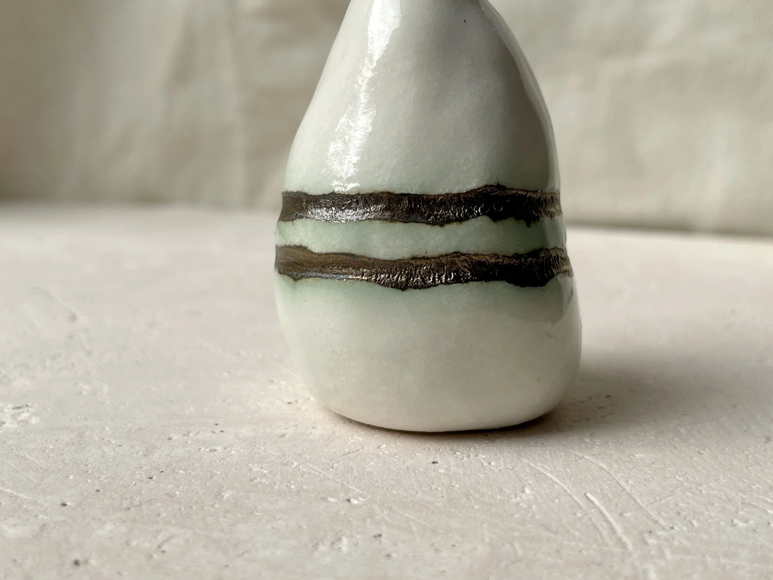 gold and white with hints of green handmade figurative ceramic sculpture with underglaze and glaze