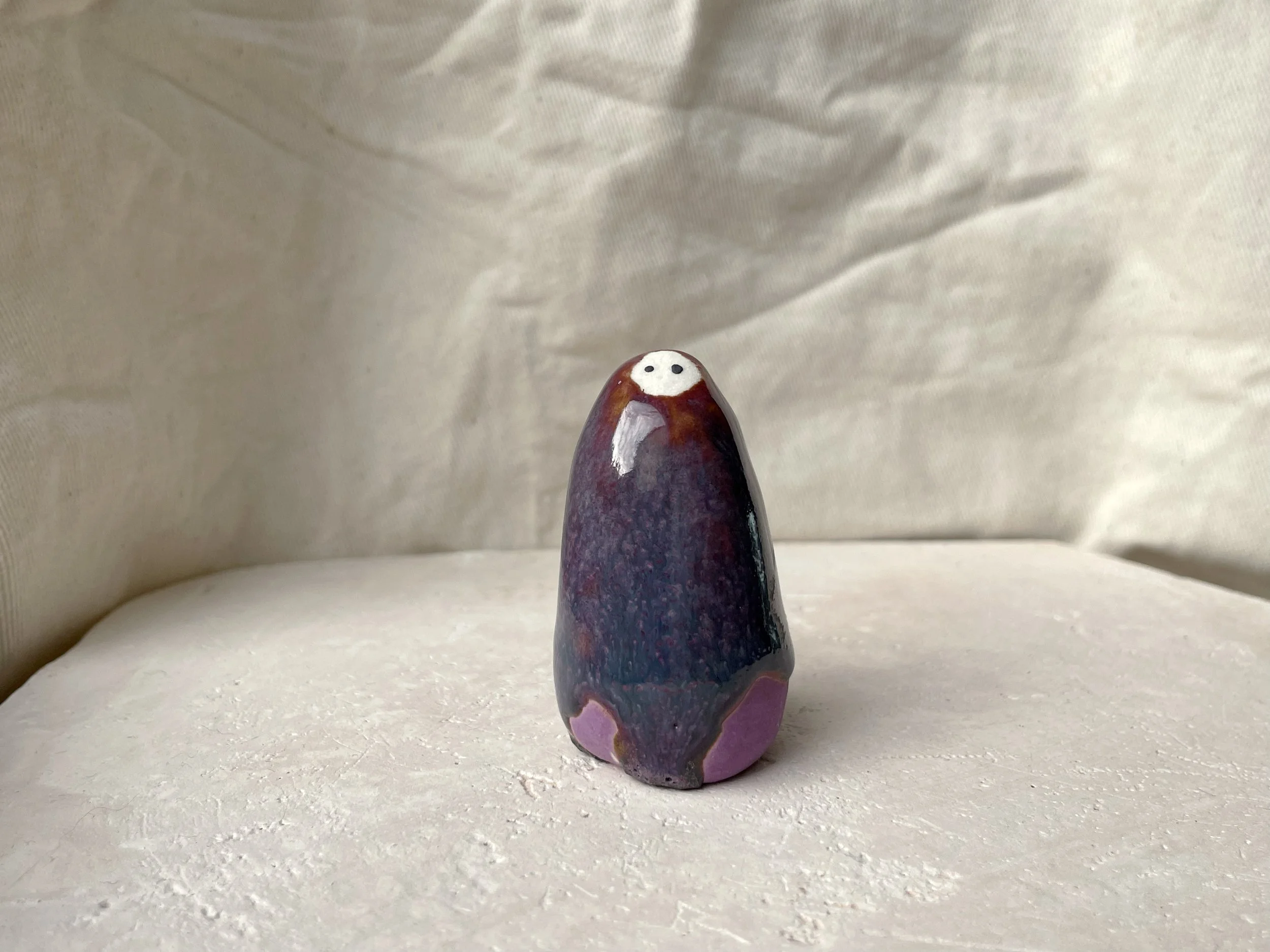Purple, blue and red handmade figurative ceramic sculpture with glossy drippy floating glaze