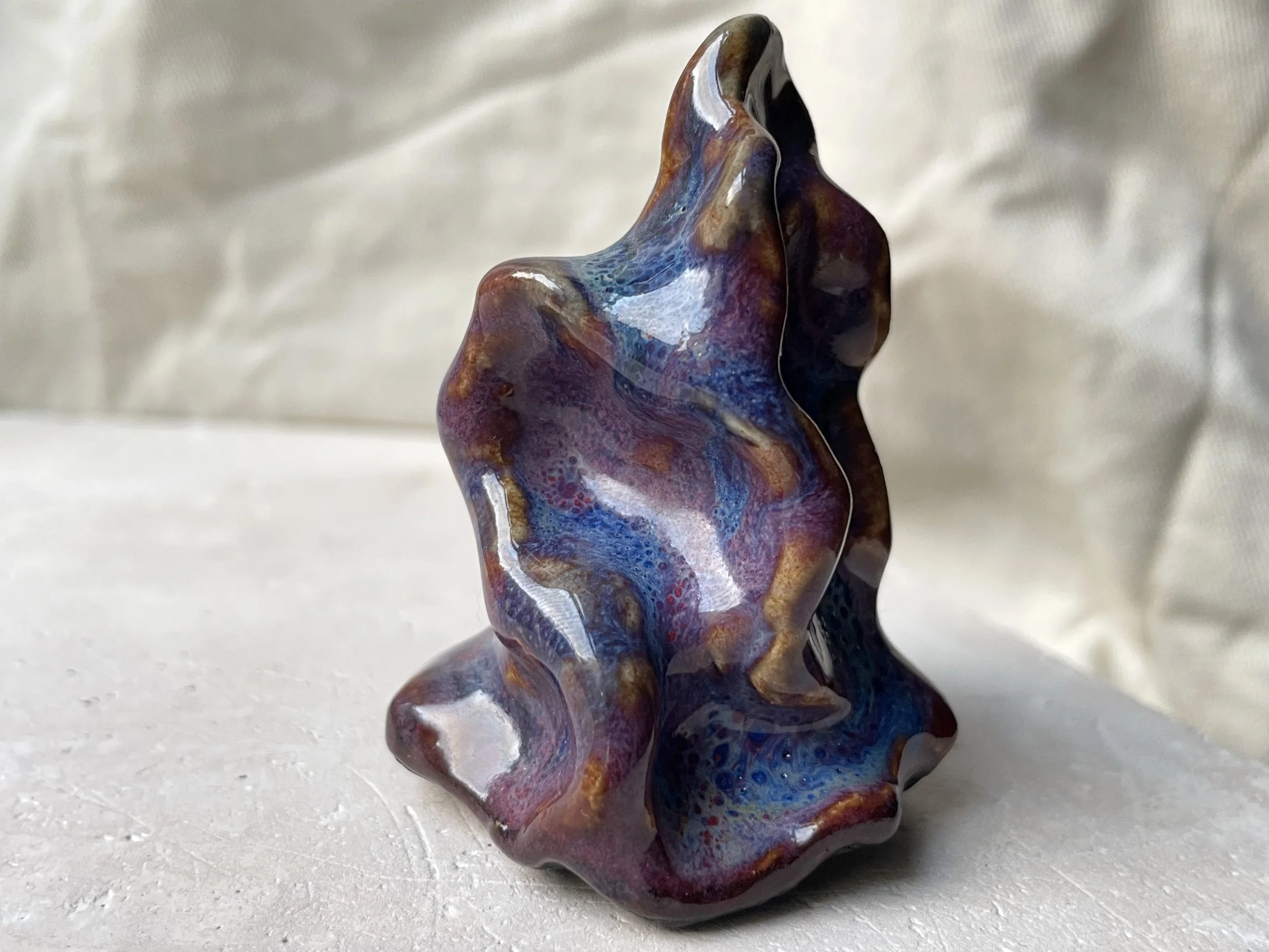 Wavy purple, red and blue handmade figurative ceramic sculpture with glossy floating glaze and underglaze