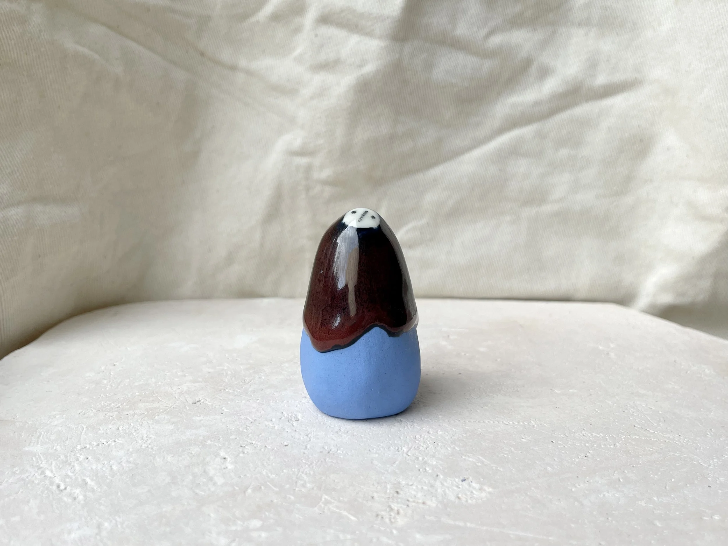 Blue, red and black handmade figurative ceramic sculpture with glossy drippy glaze
