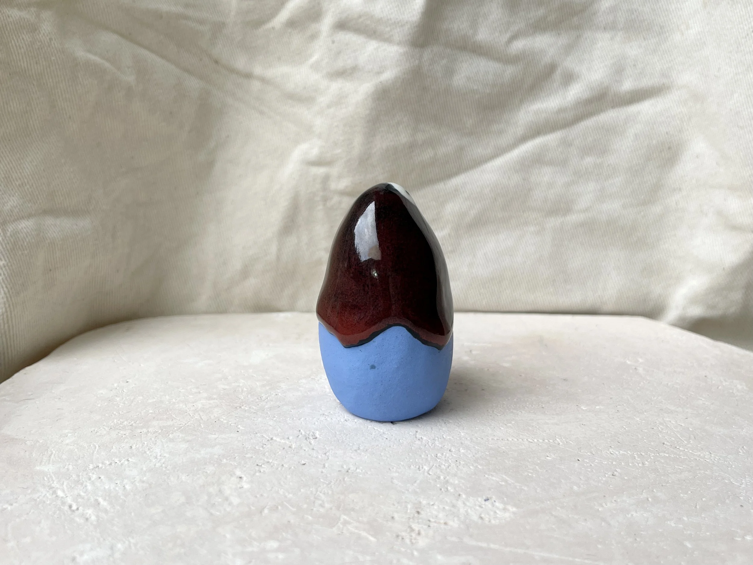 Blue, red and black handmade figurative ceramic sculpture with underglaze and drippy float glaze