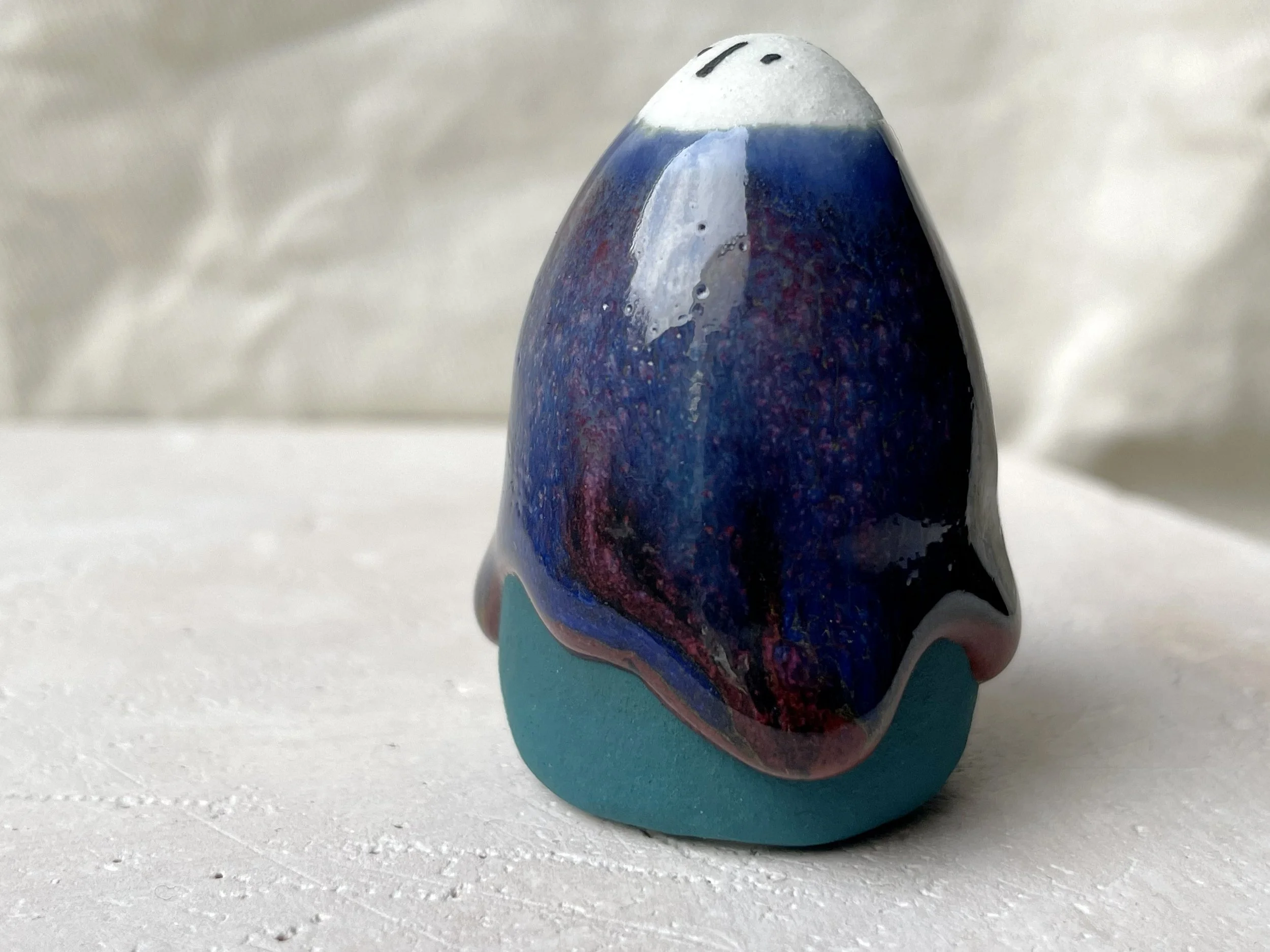 Blue, green and red handmade figurative ceramic sculpture with underglaze and drippy runny glaze