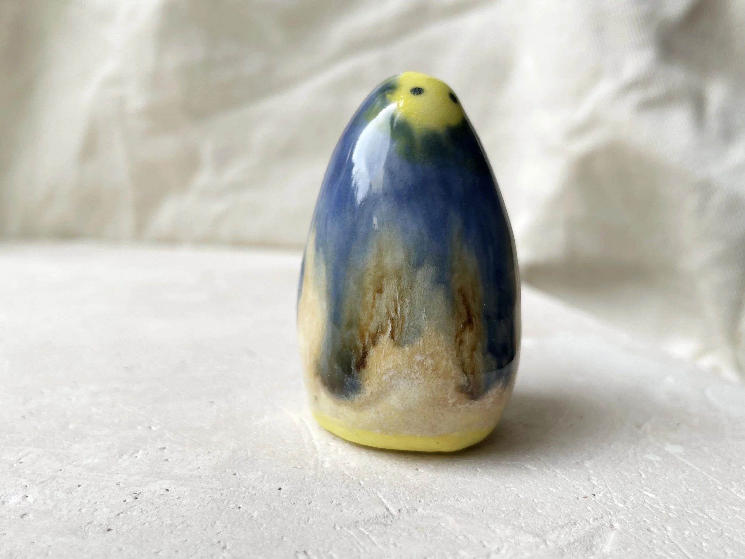 Yellow, blue and cream handmade figurative ceramic sculpture with glossy drippy glaze