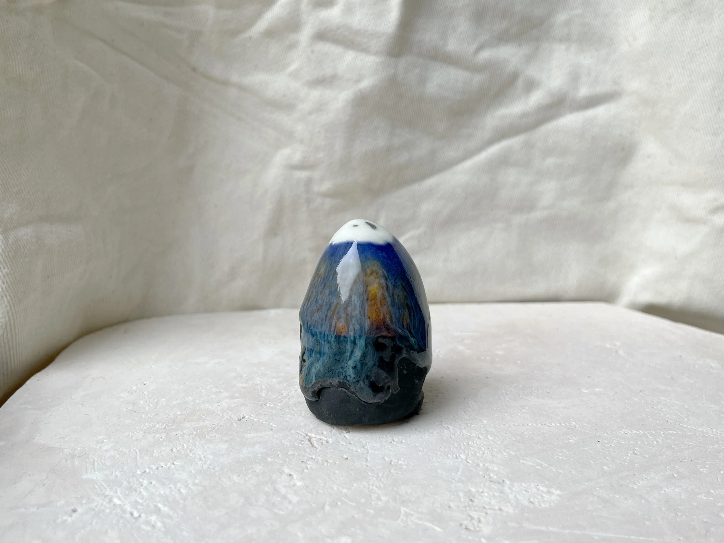 Blue, orange, black handmade figurative ceramic sculpture with glossy runny floating glaze