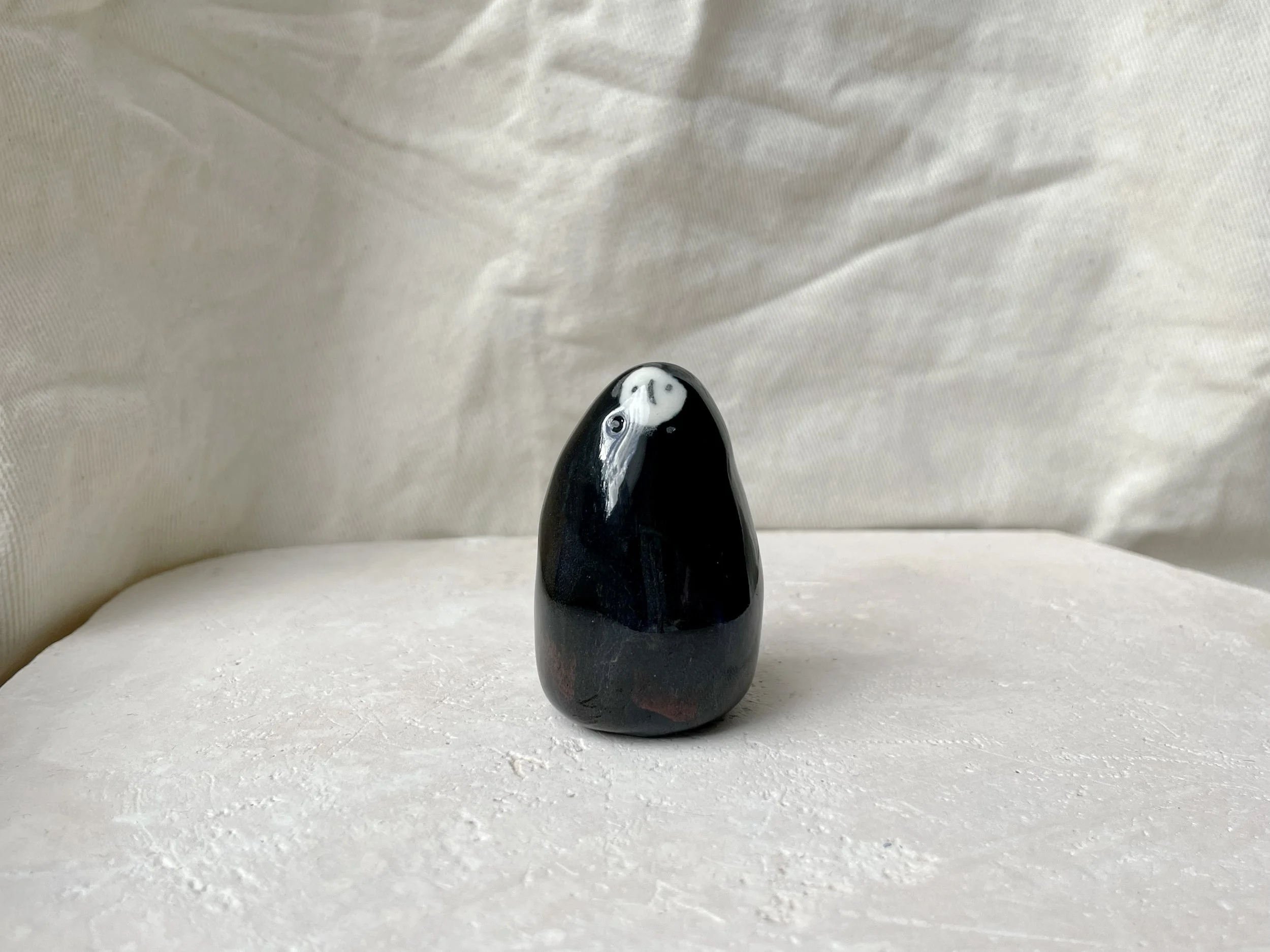 black and red handmade figurative ceramic sculpture with runny floating glaze