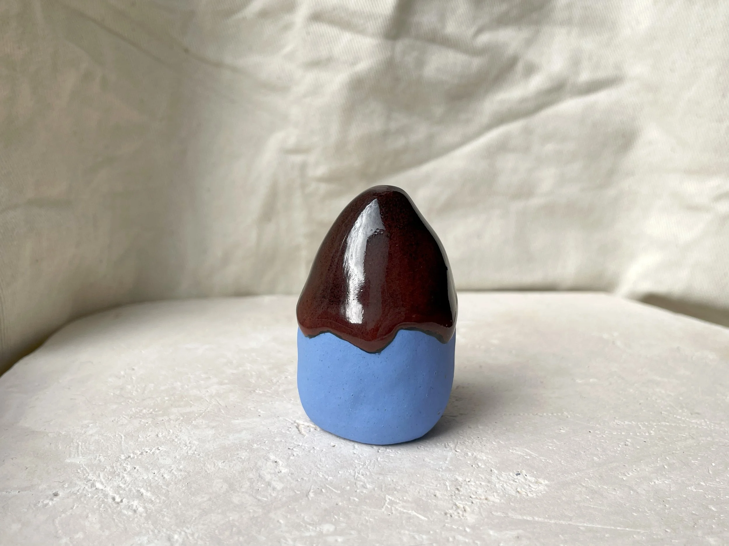 Blue, black and red handmade figurative ceramic sculpture with glossy drippy floating glaze