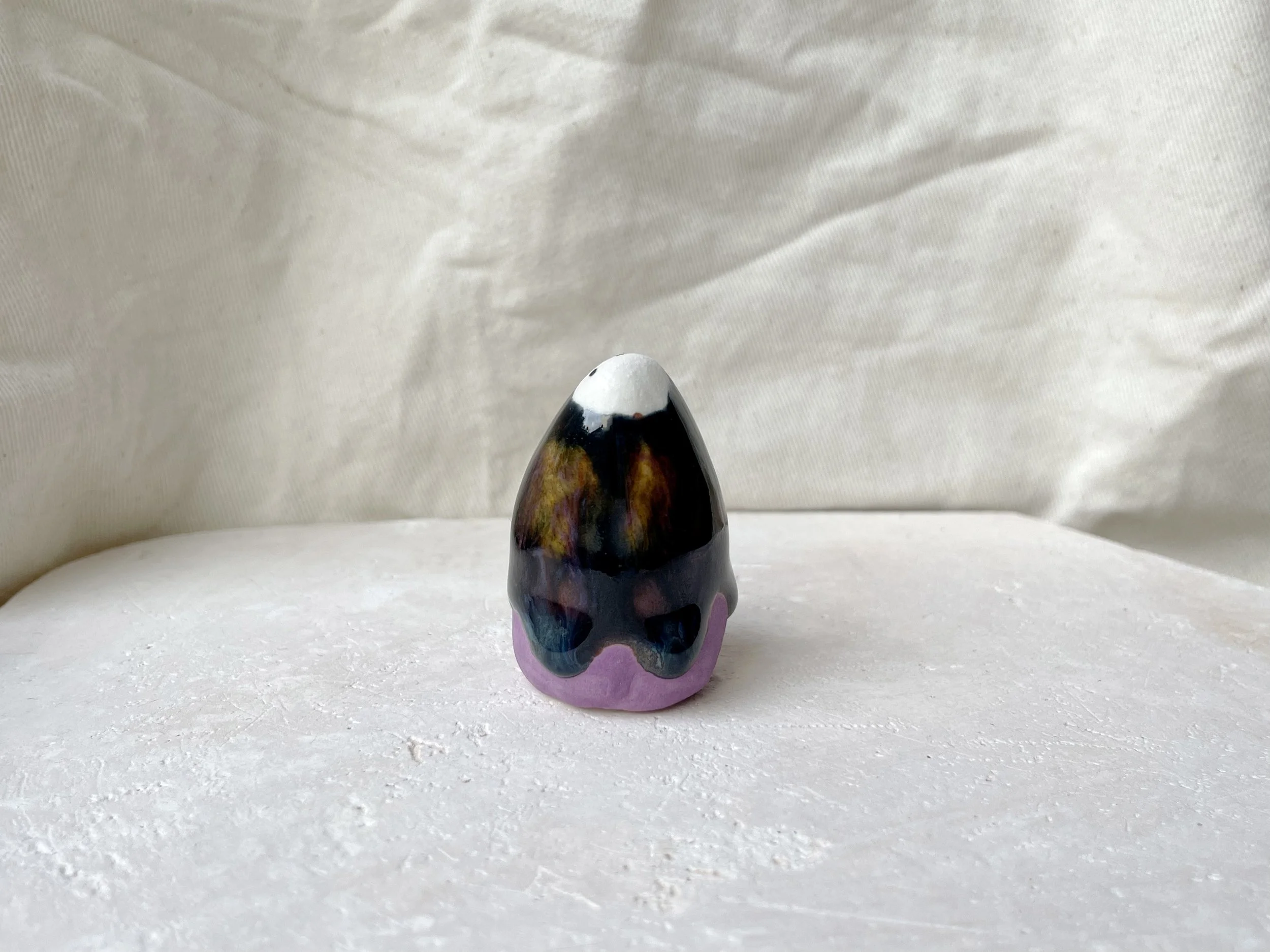 Purple, black, orange, blue handmade figurative ceramic sculpture with underglaze and drippy runny glaze
