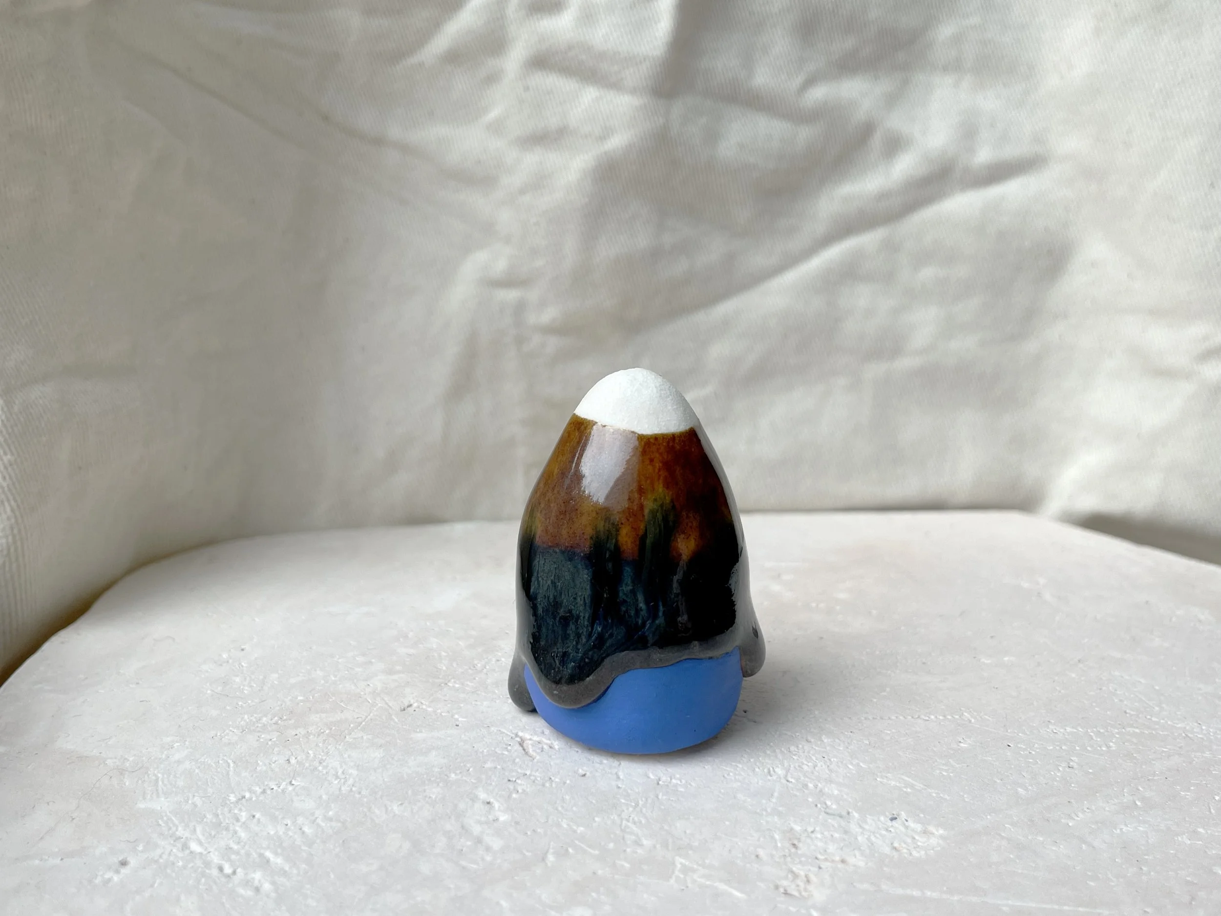 Blue, brown and black handmade figurative ceramic sculpture with runny drippy glaze