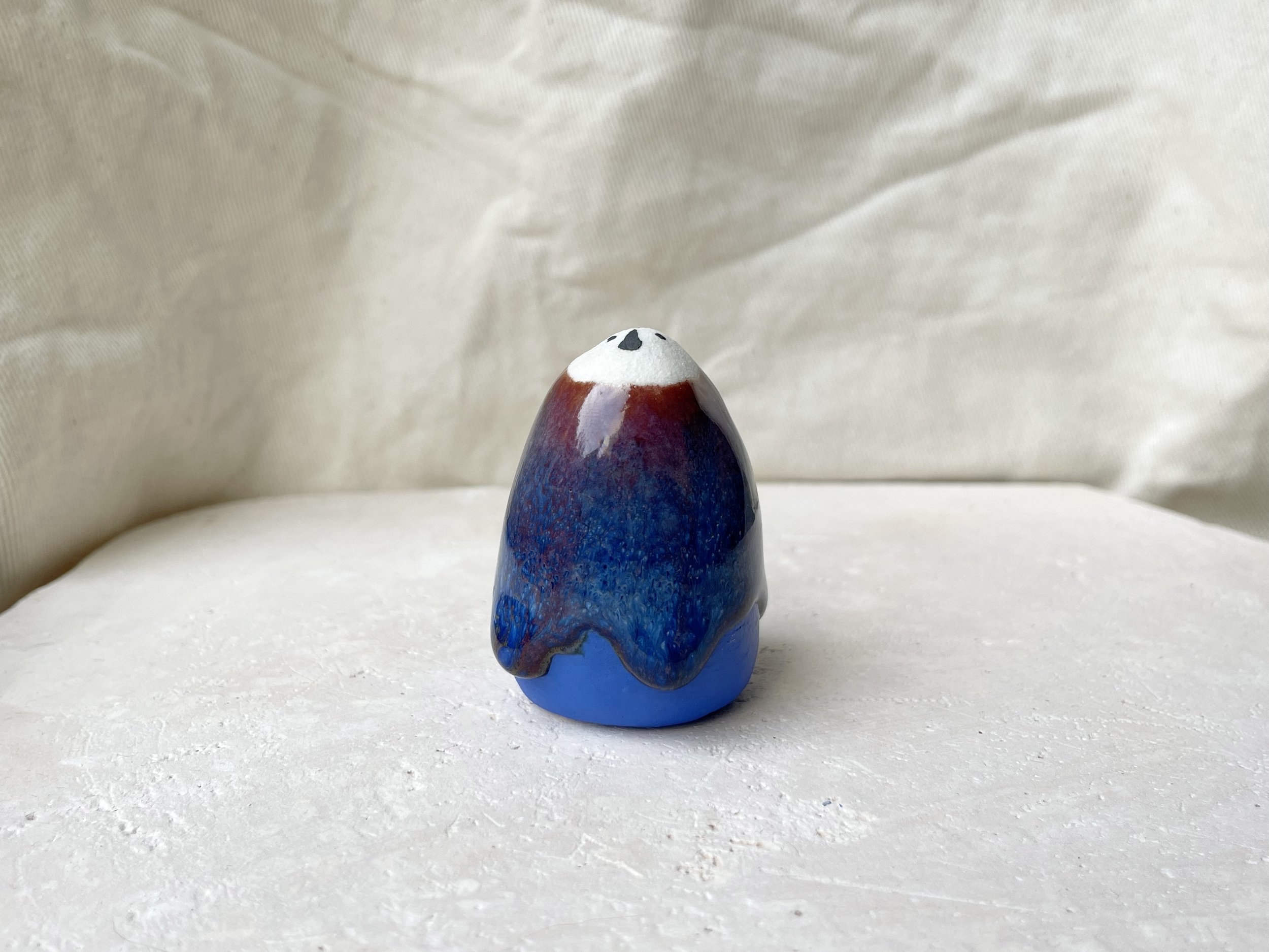 Red, blue and gold handmade figurative ceramic sculpture with underglaze and drippy runny glaze