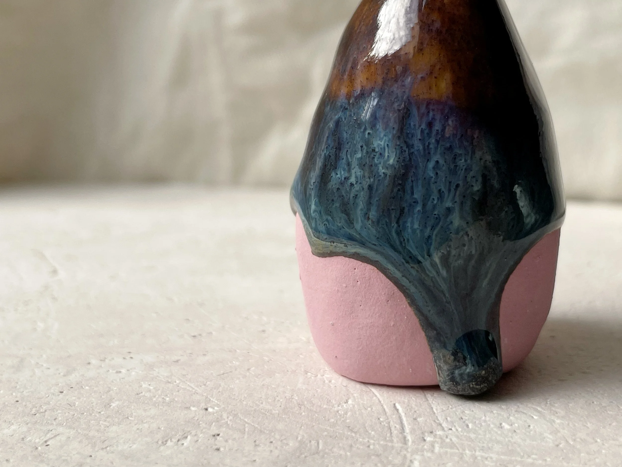 Brown, blue and pink handmade figurative ceramic sculpture with glossy drippy floating glaze
