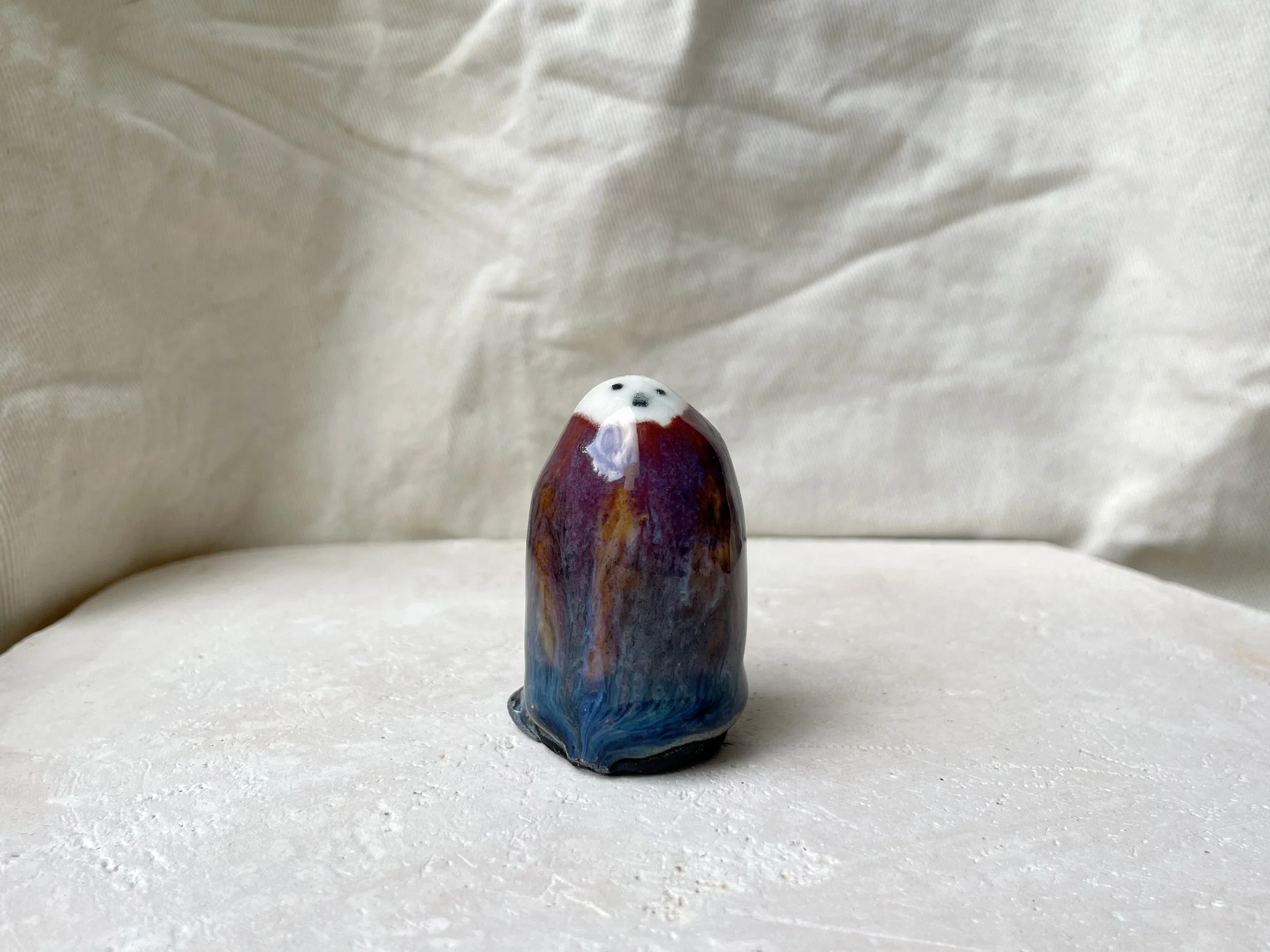 Purple, orange, blue and black handmade figurative ceramic sculpture with underglaze and drippy float glaze