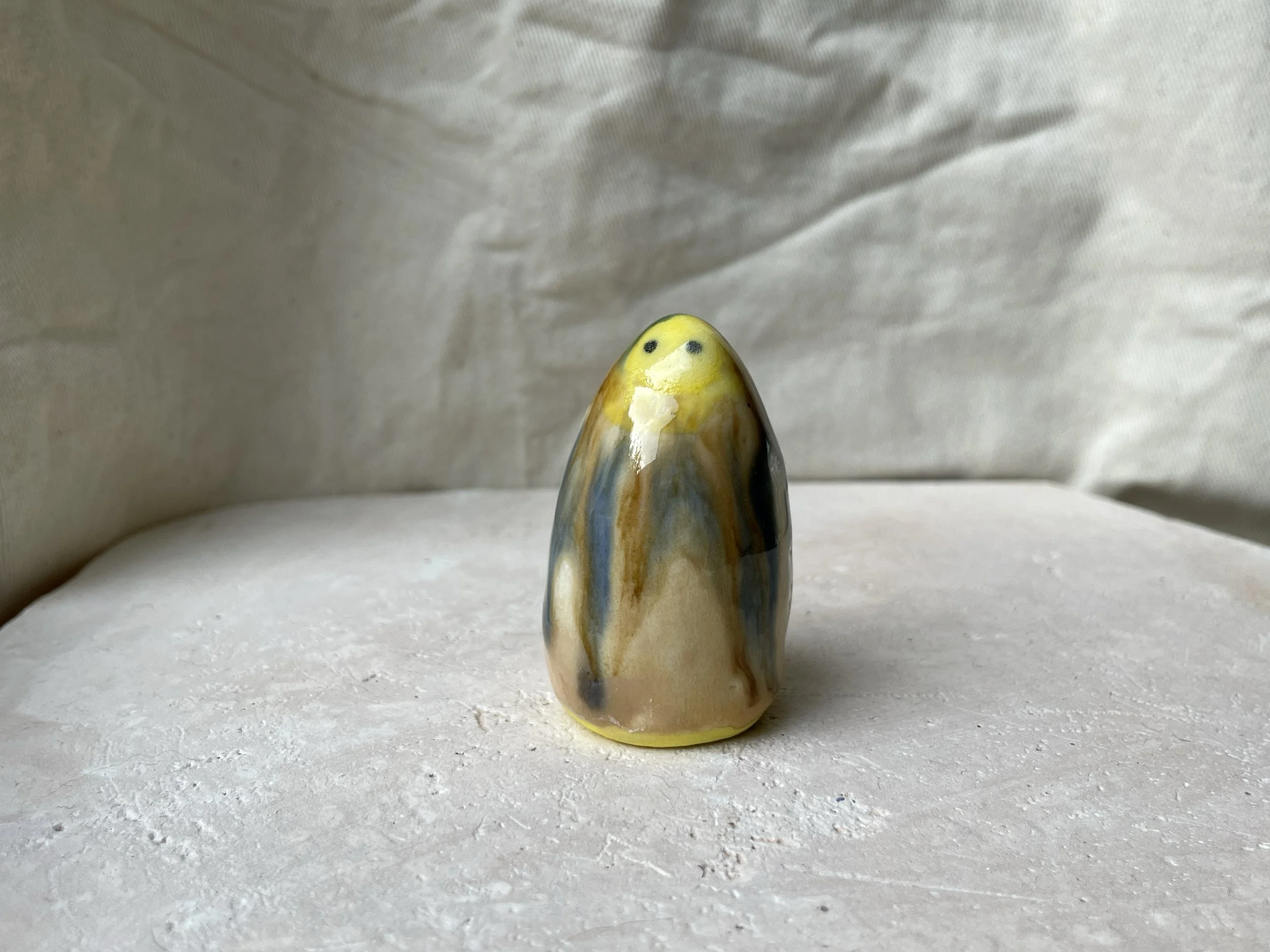 Yellow, brown, blue and cream handmade figurative ceramic sculpture with glossy drippy glaze