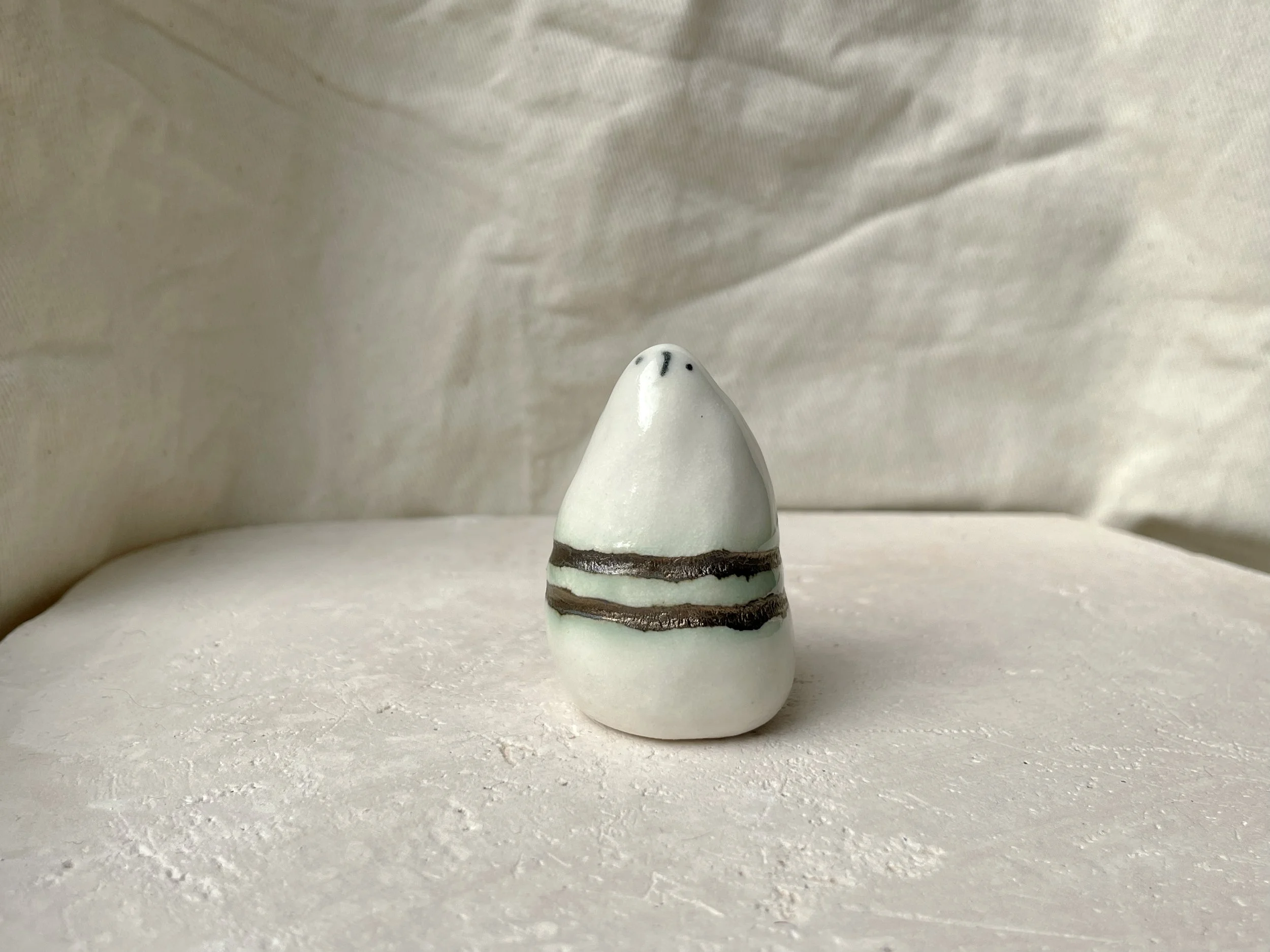 gold and white with hints of green handmade figurative ceramic sculpture with underglaze and glaze