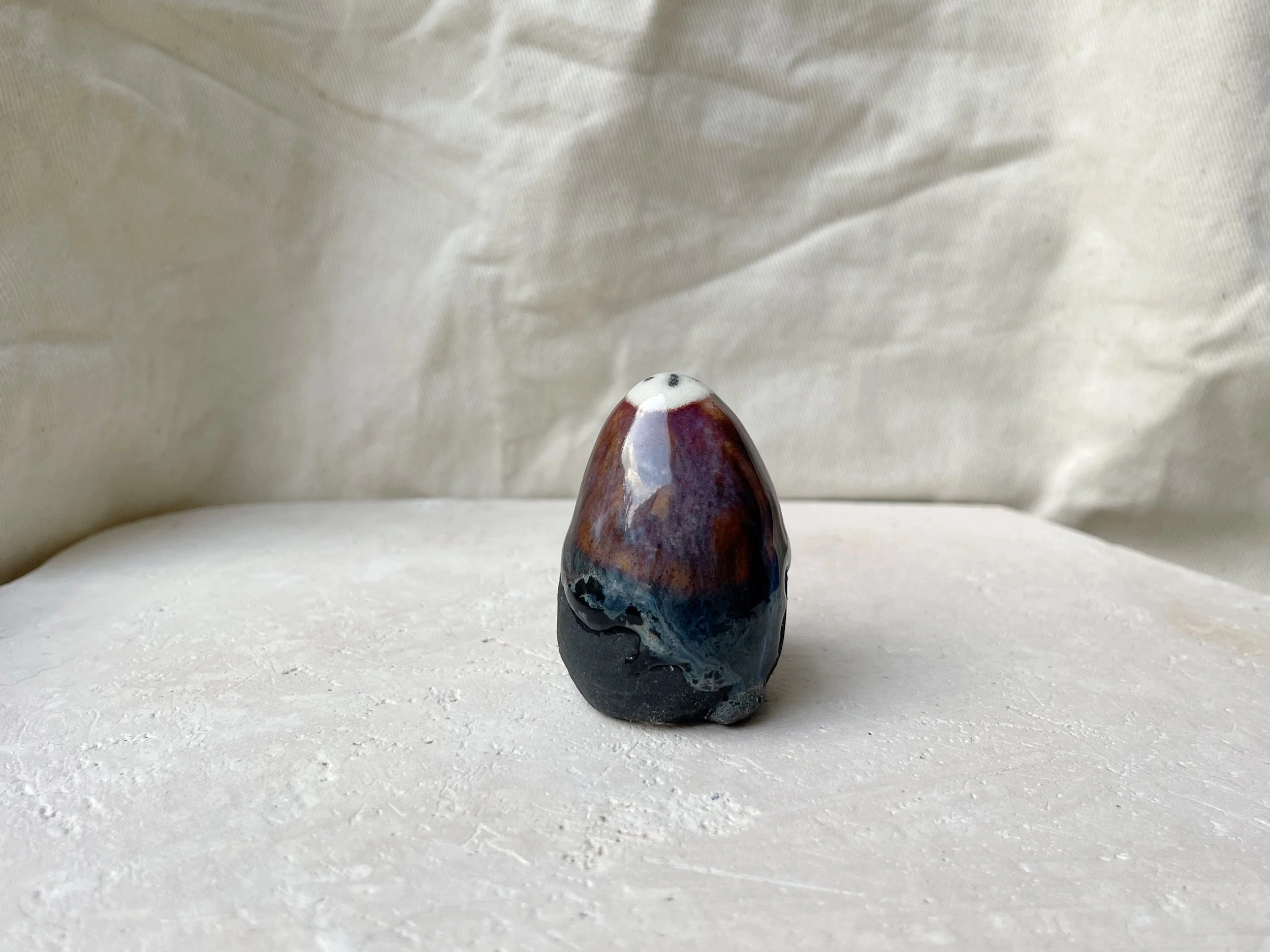 Blue, orange, purple and black handmade figurative ceramic sculpture with underglaze and drippy float glaze