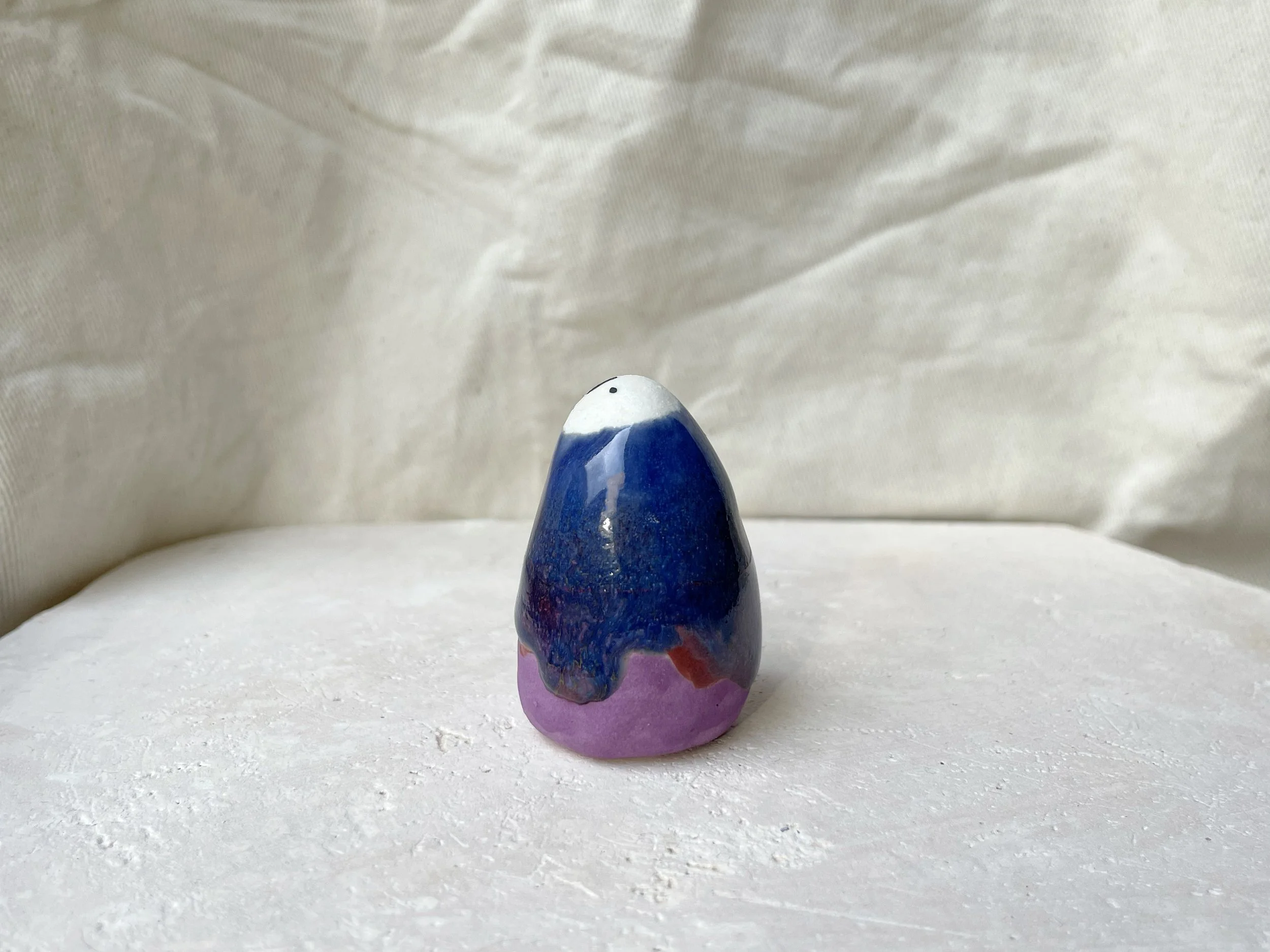 Purple, blue and red handmade figurative ceramic sculpture with glossy drippy glaze