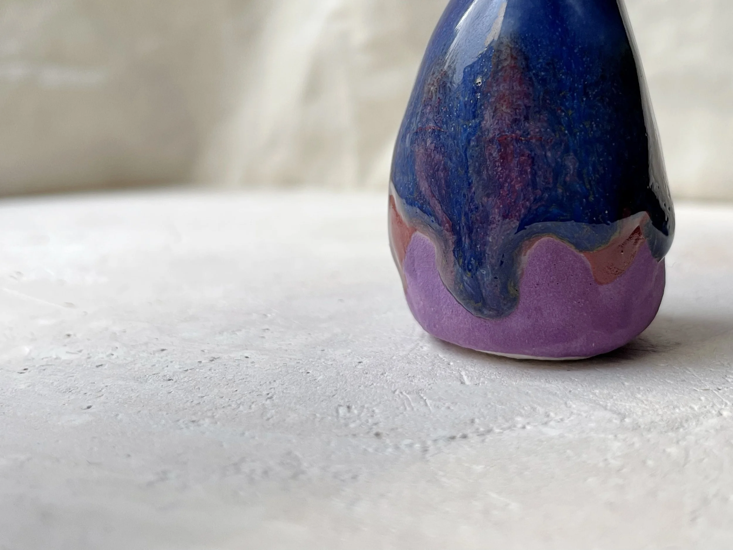 Purple, blue and red handmade figurative ceramic sculpture with glossy drippy glaze