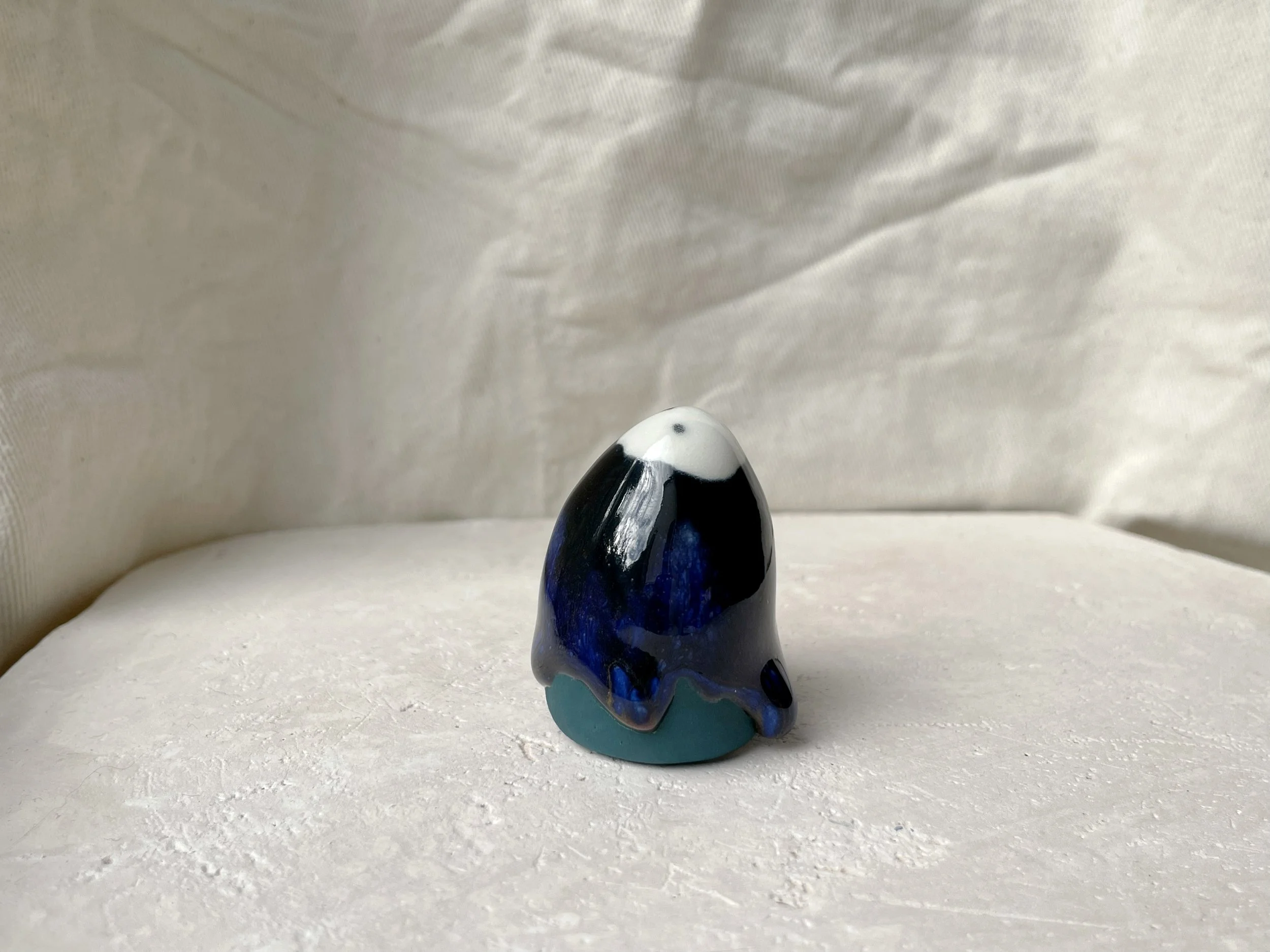 Black, blue and green handmade figurative ceramic sculpture with glossy drippy floating glaze