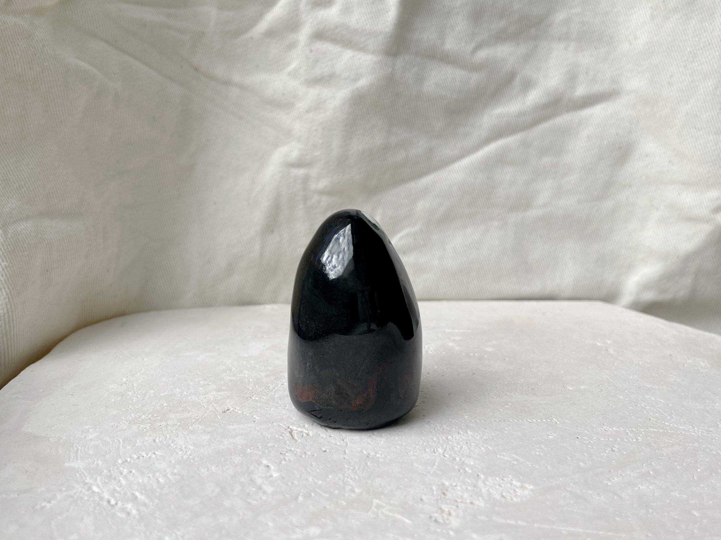 black and red handmade figurative ceramic sculpture with runny floating glaze