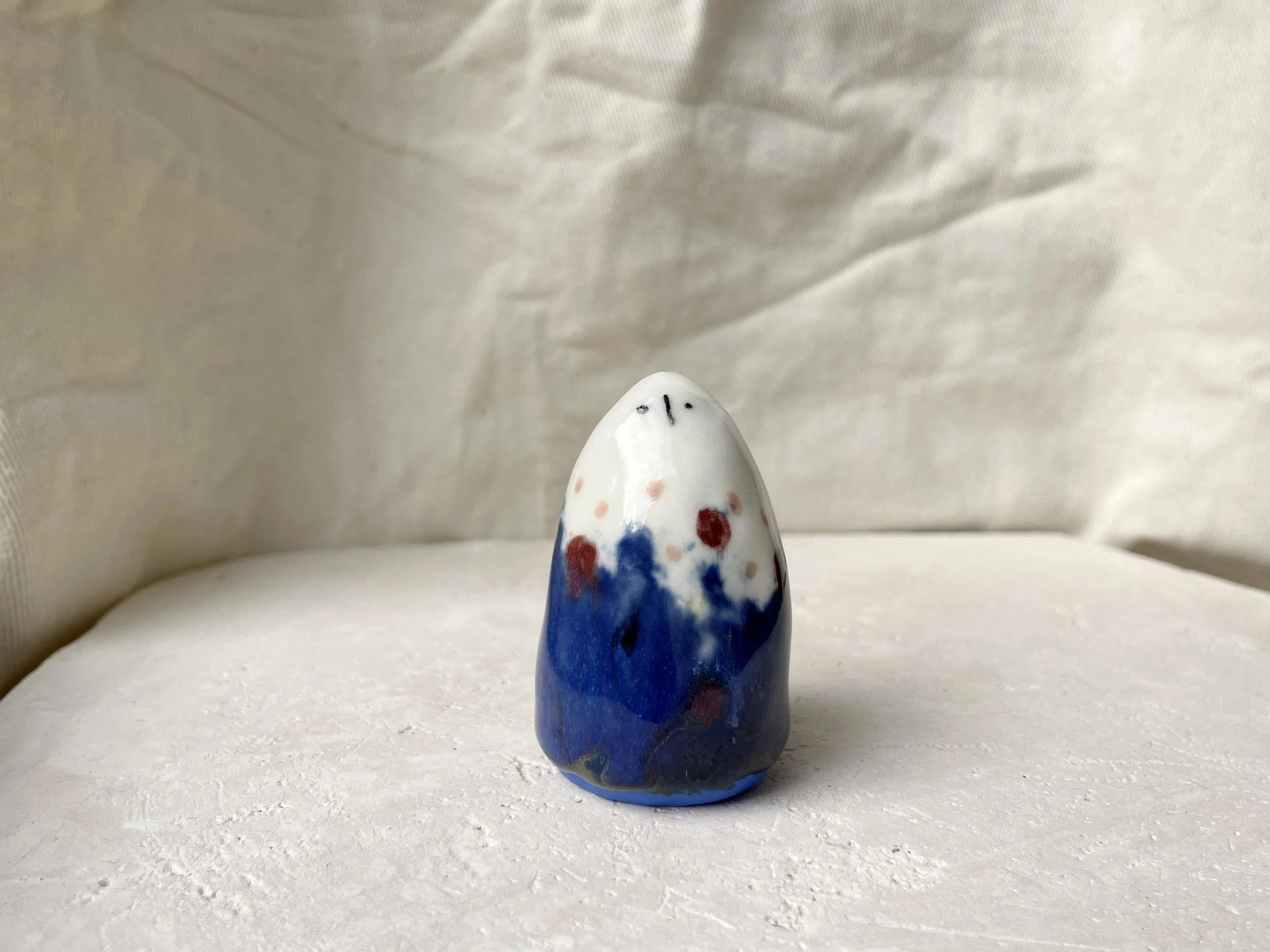 blue, white, red and pink handmade figurative ceramic sculpture with underglaze and glaze
