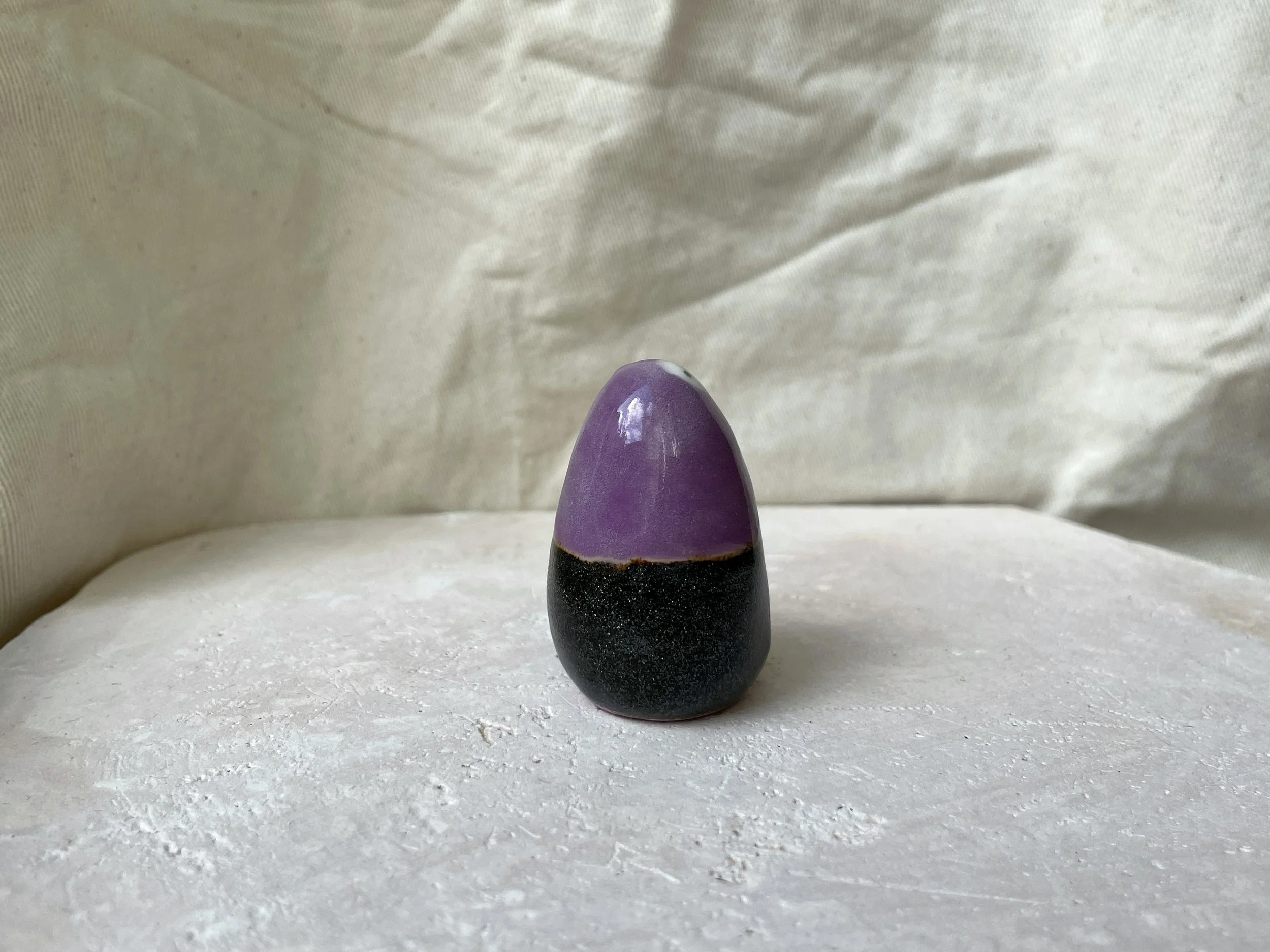 black and purple handmade figurative ceramic sculpture with sparkling cosmic glaze