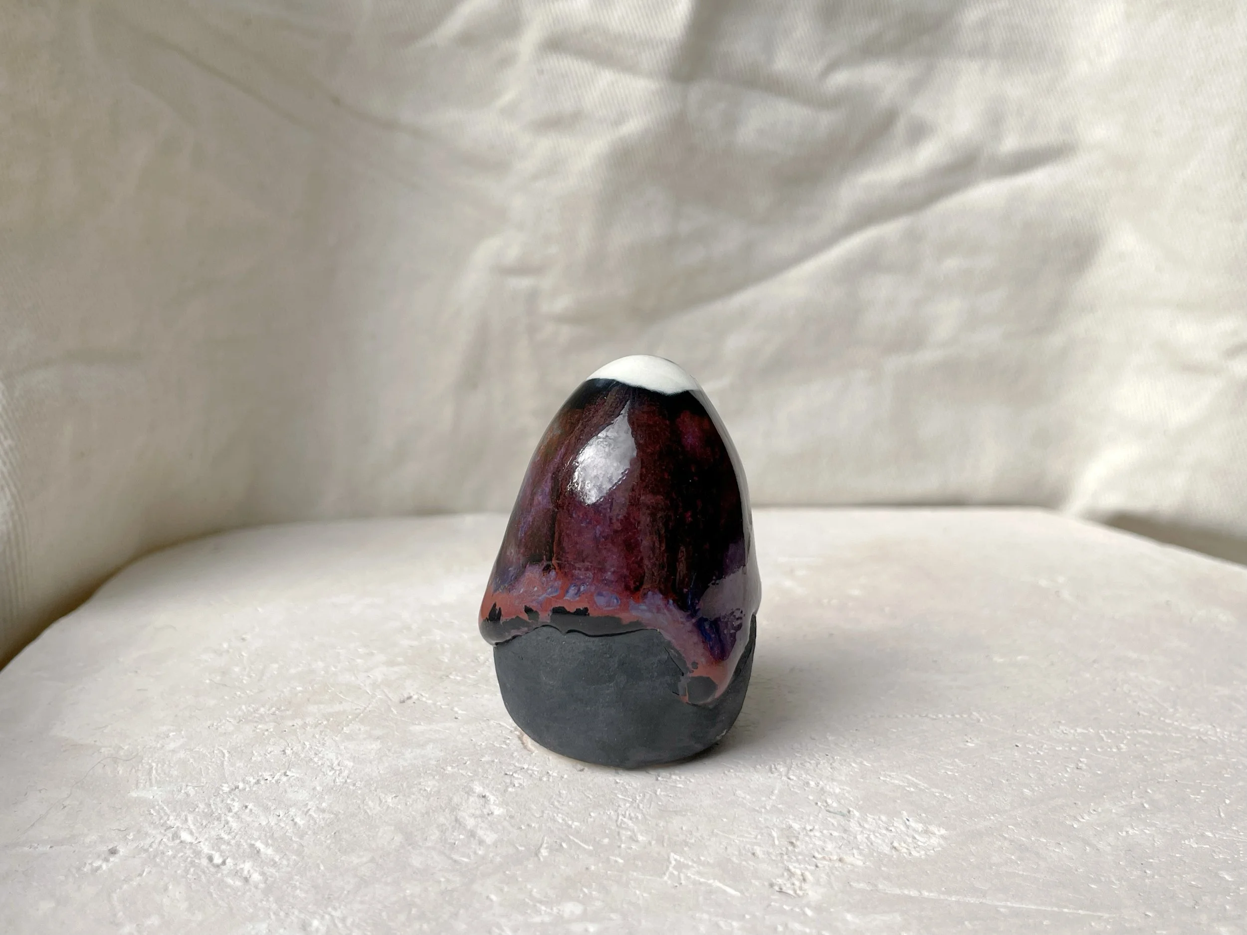 purple, black and red handmade figurative ceramic sculpture with glossy drippy floating glaze