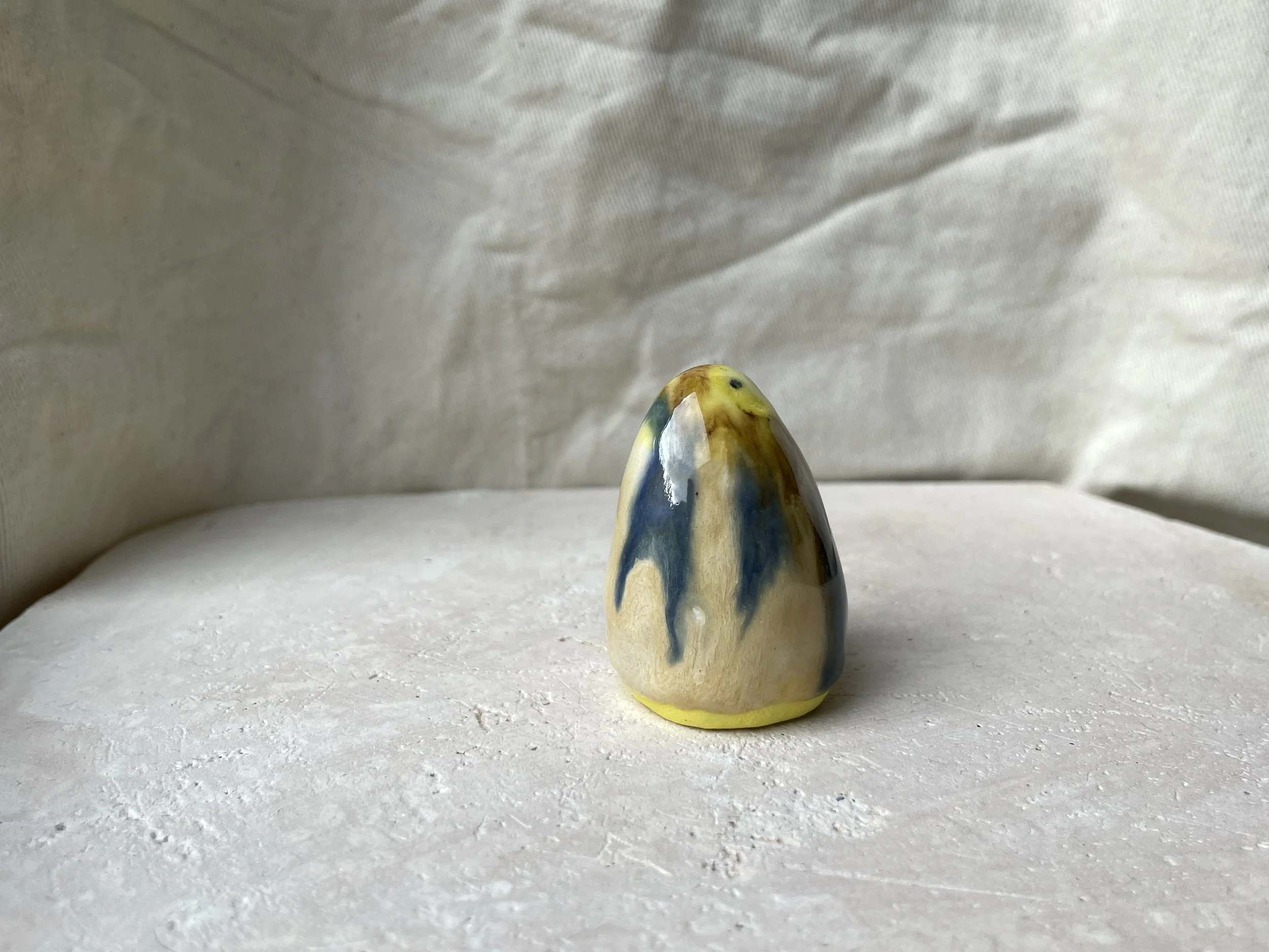 Yellow, brown, blue and cream handmade figurative ceramic sculpture with glossy drippy glaze