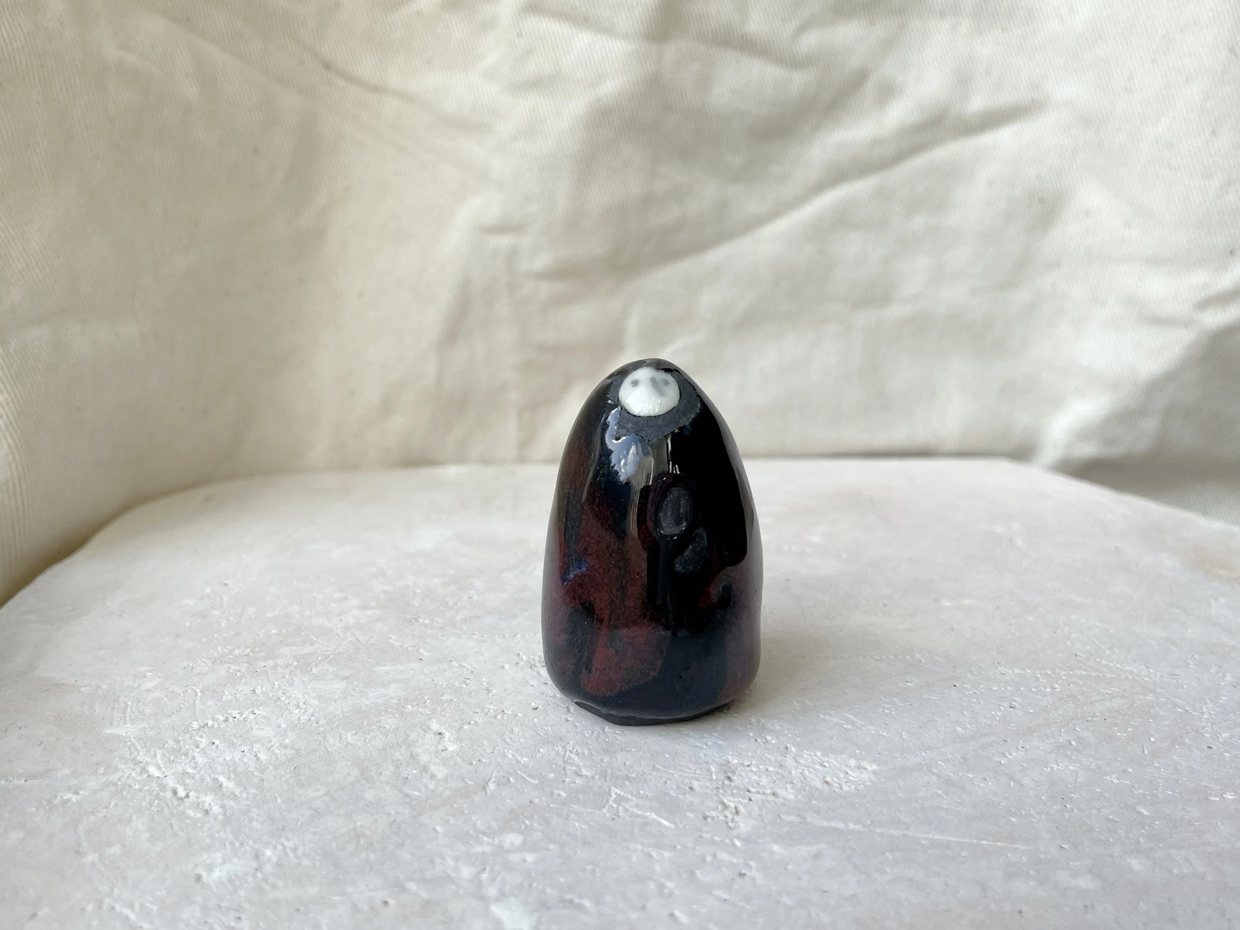 black and red handmade figurative ceramic sculpture with runny glaze
