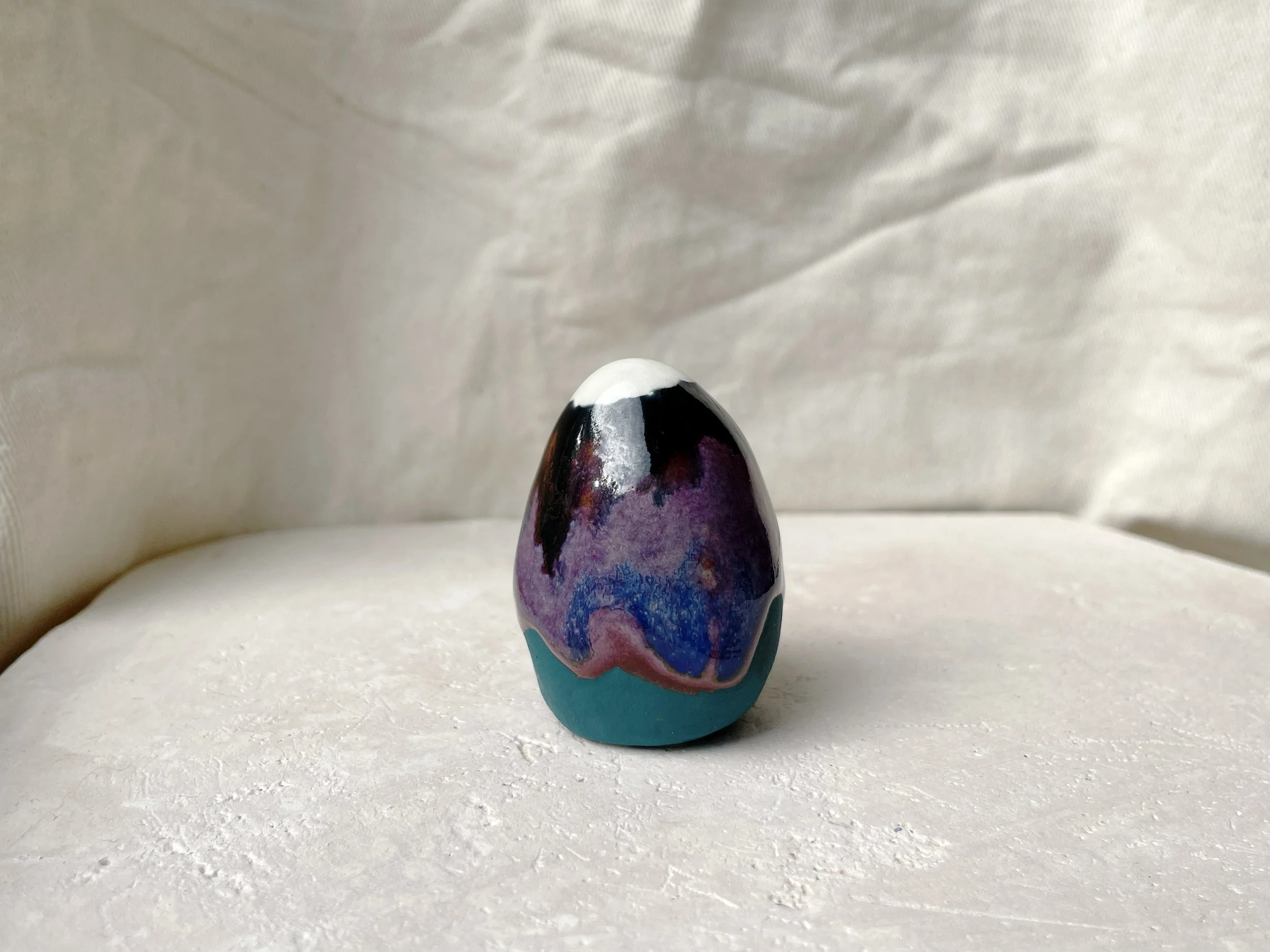 Black, purple, green and red handmade figurative ceramic sculpture with glossy drippy floating glaze