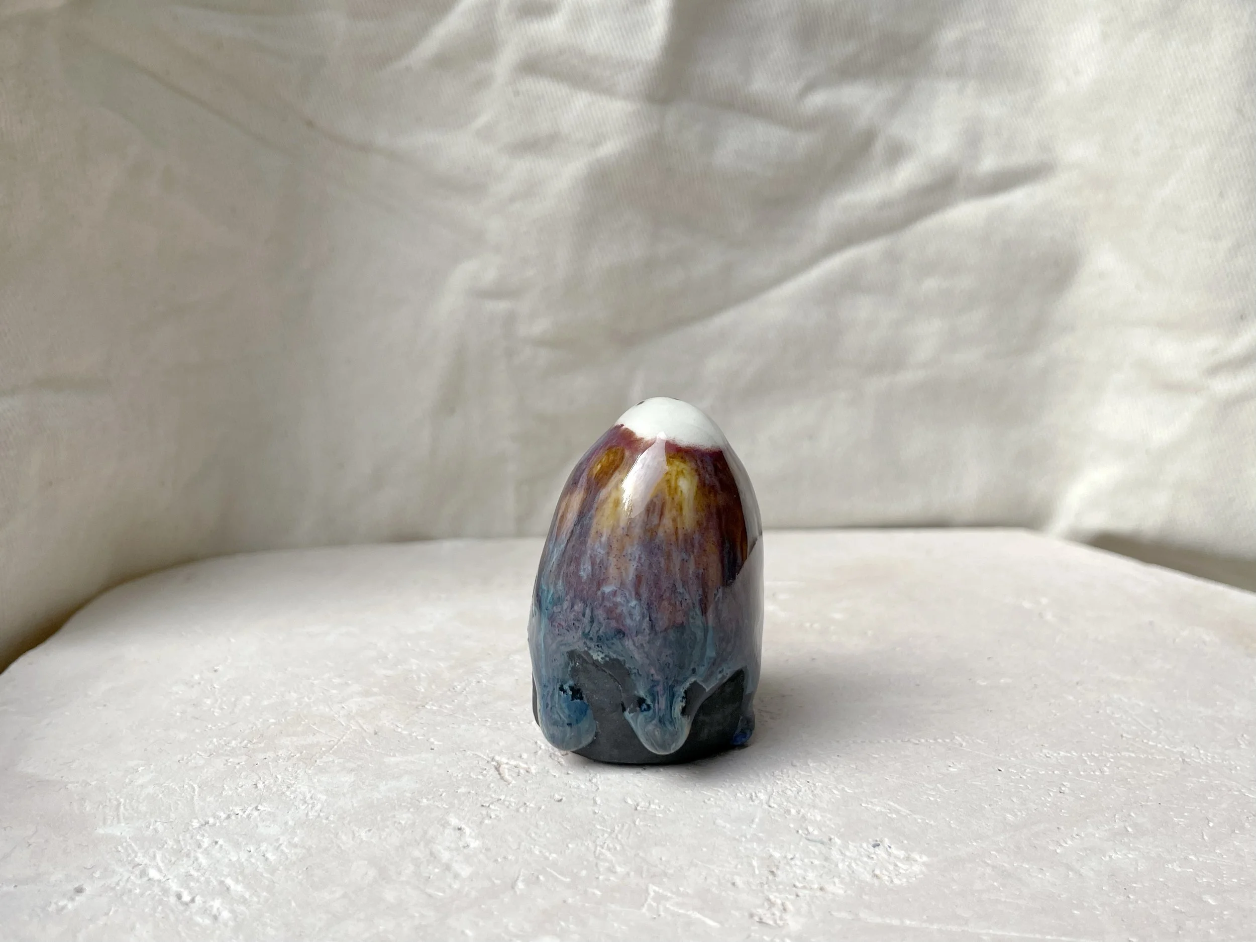 pink, blue, yellow, black handmade figurative ceramic sculpture with glossy floating glaze