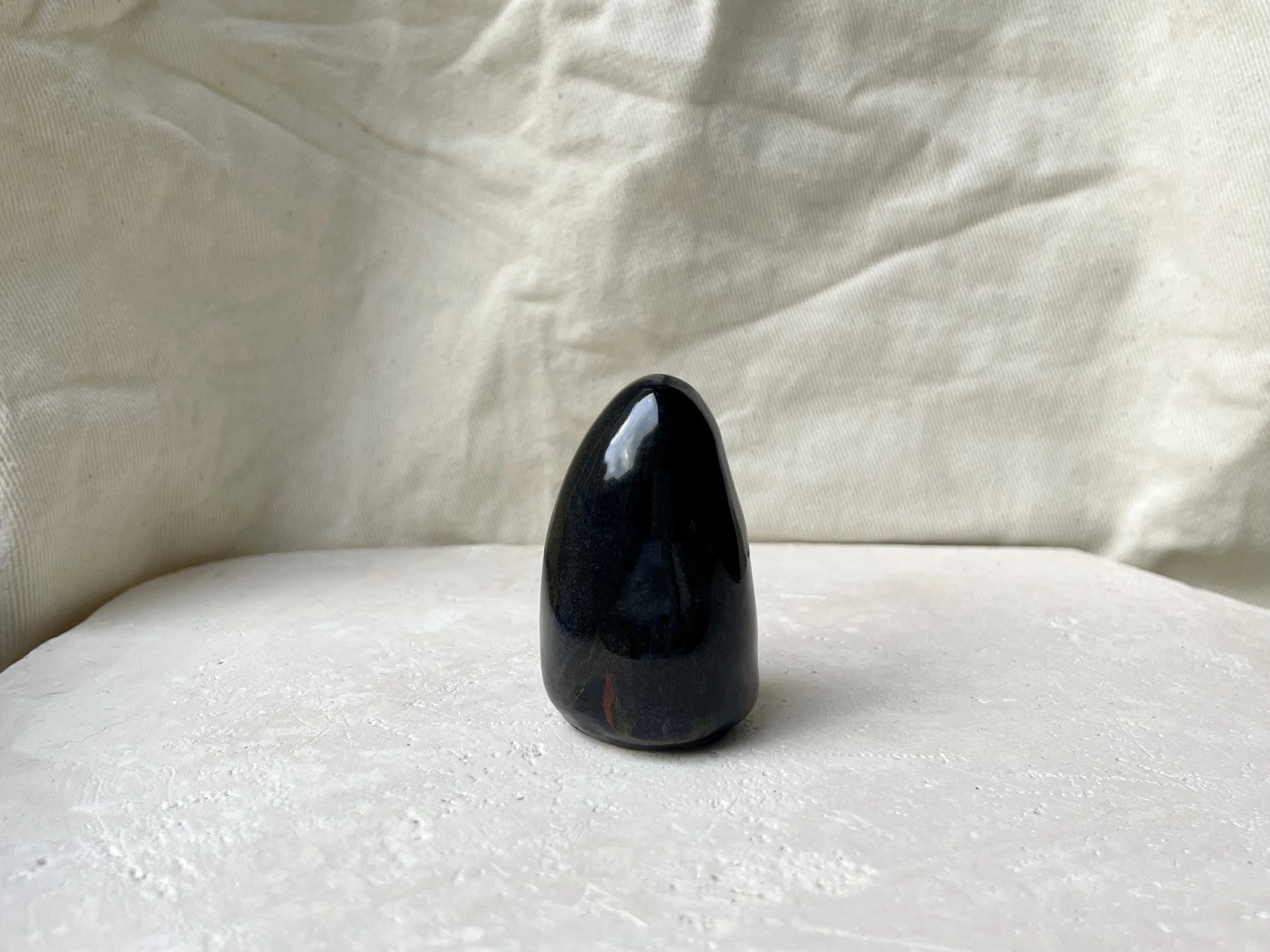 Black and red handmade figurative ceramic sculpture with glossy floating glaze
