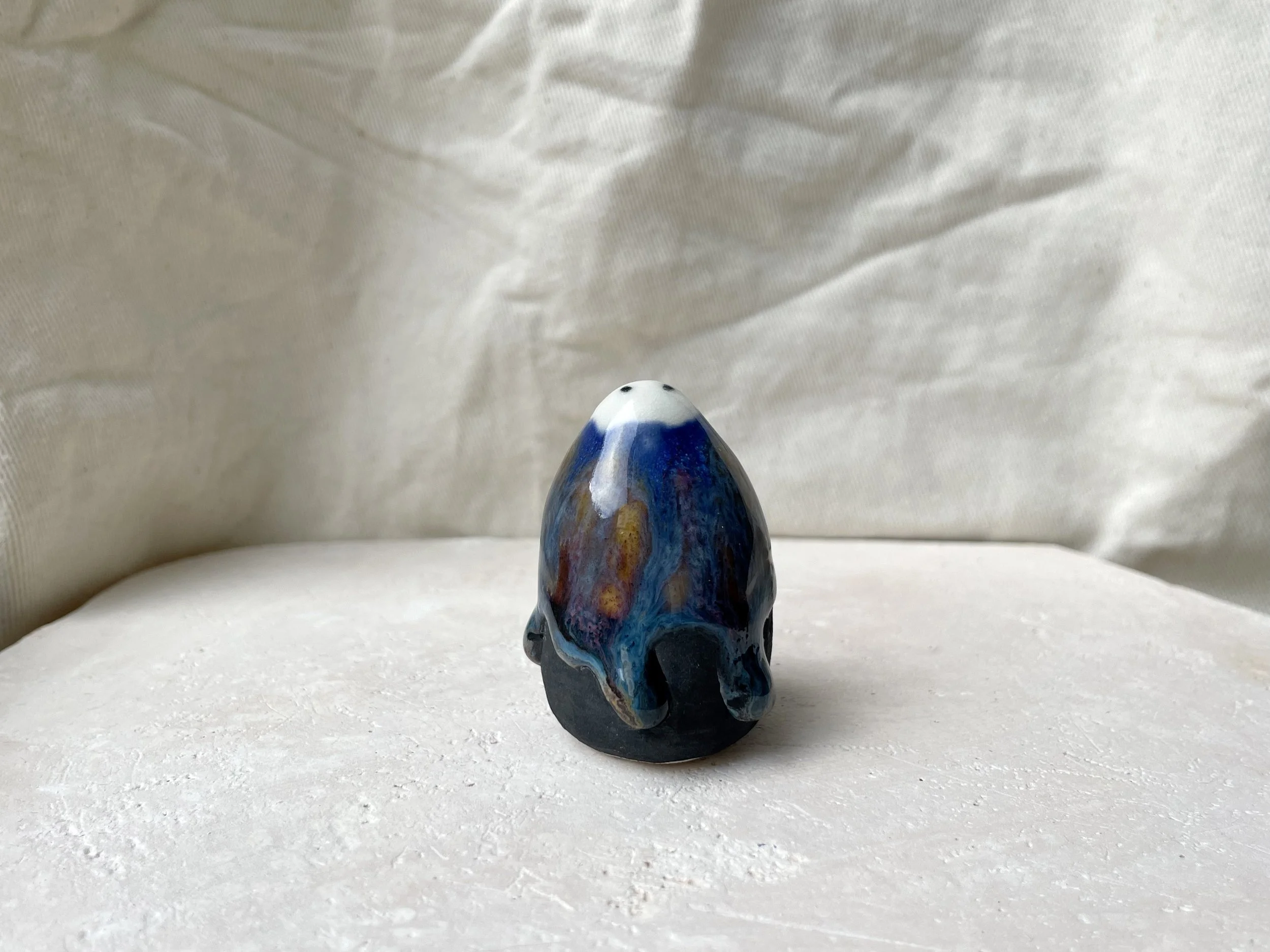 Blue, orange, purple and black handmade figurative ceramic sculpture with underglaze and drippy float glaze