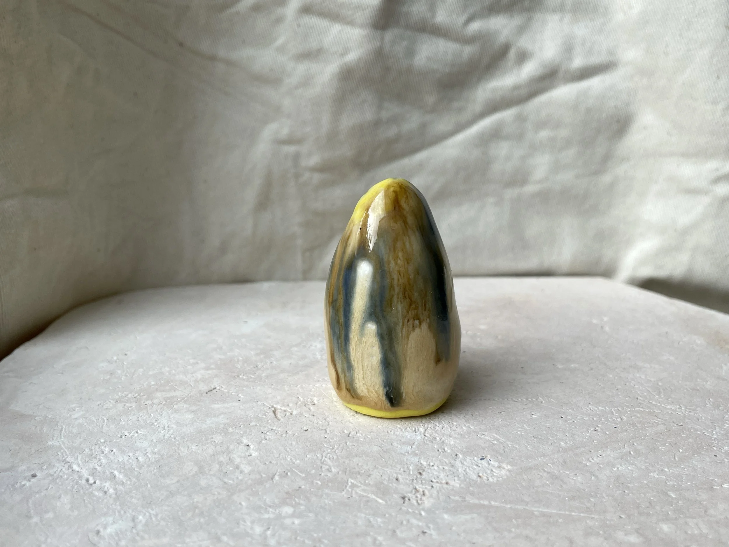 Yellow, brown, blue and cream handmade figurative ceramic sculpture with glossy drippy glaze