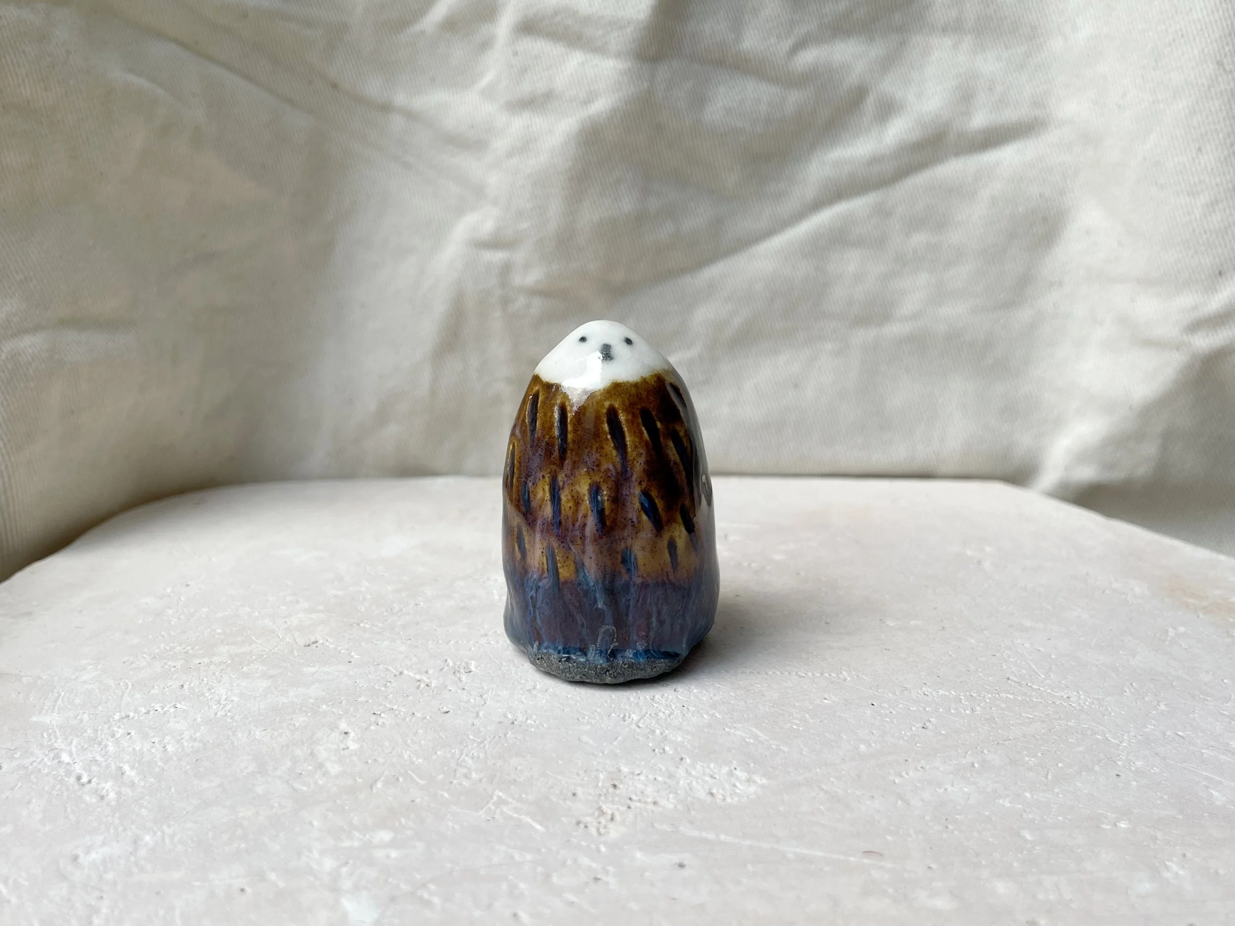 brown, purple and blue handmade figurative ceramic sculpture with underglaze and drippy float glaze