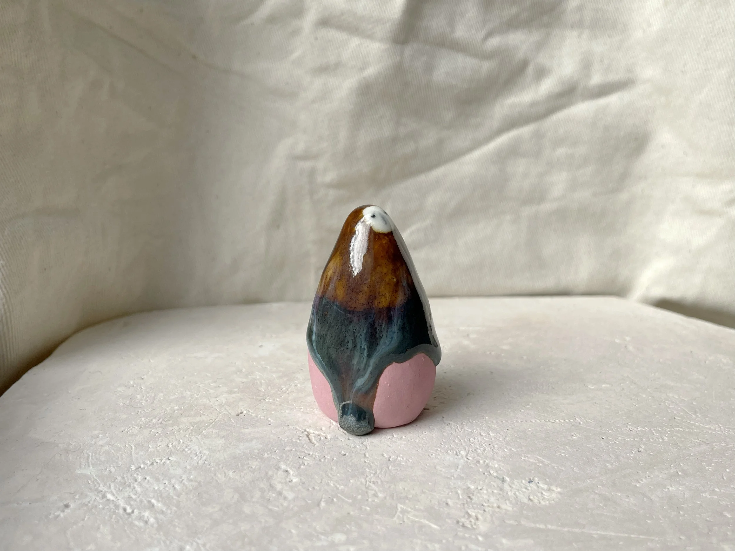 Brown, blue and pink handmade figurative ceramic sculpture with glossy drippy floating glaze