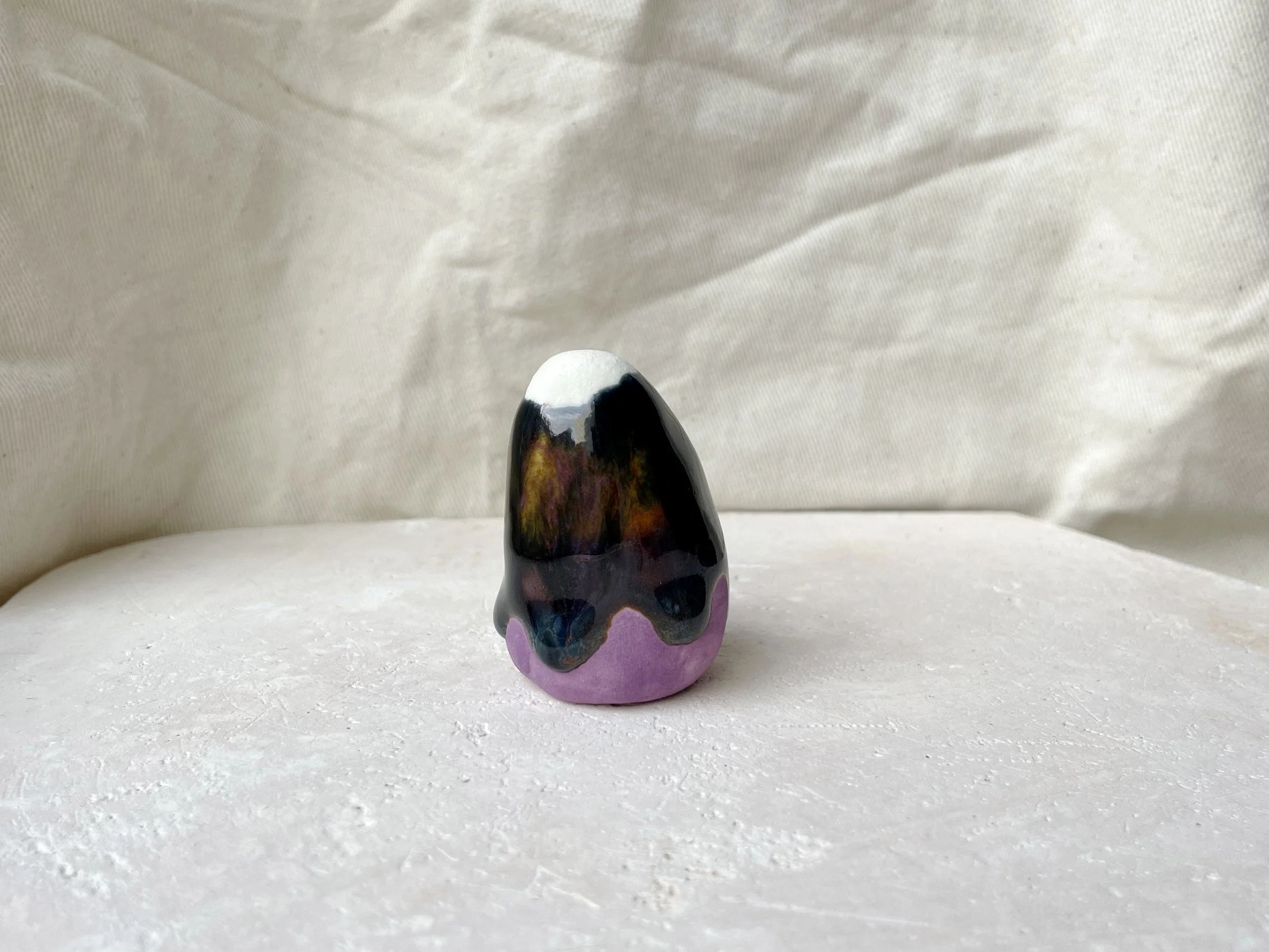 Purple, black, orange, blue handmade figurative ceramic sculpture with underglaze and drippy runny glaze