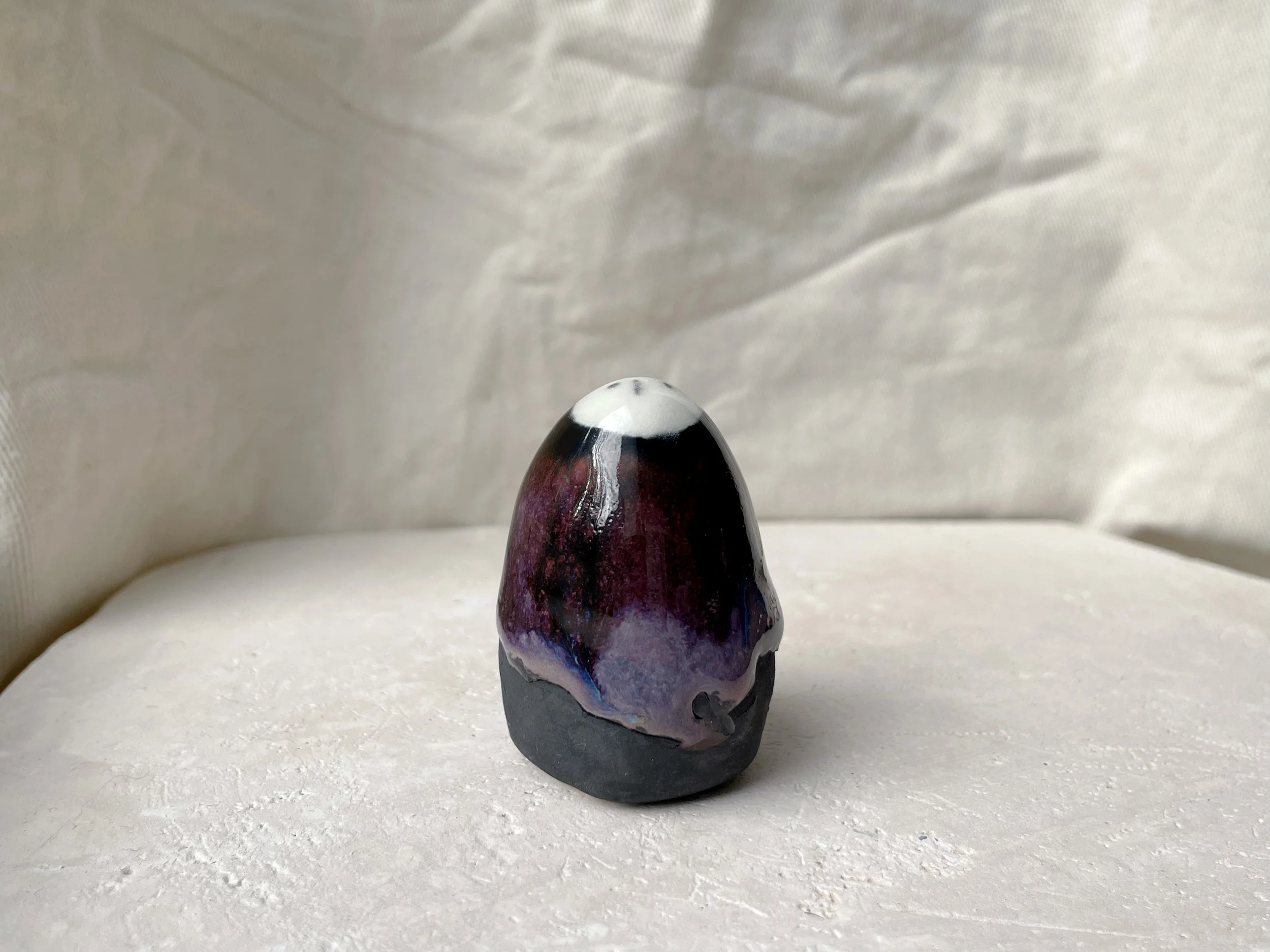 purple, black and red handmade figurative ceramic sculpture with glossy drippy floating glaze