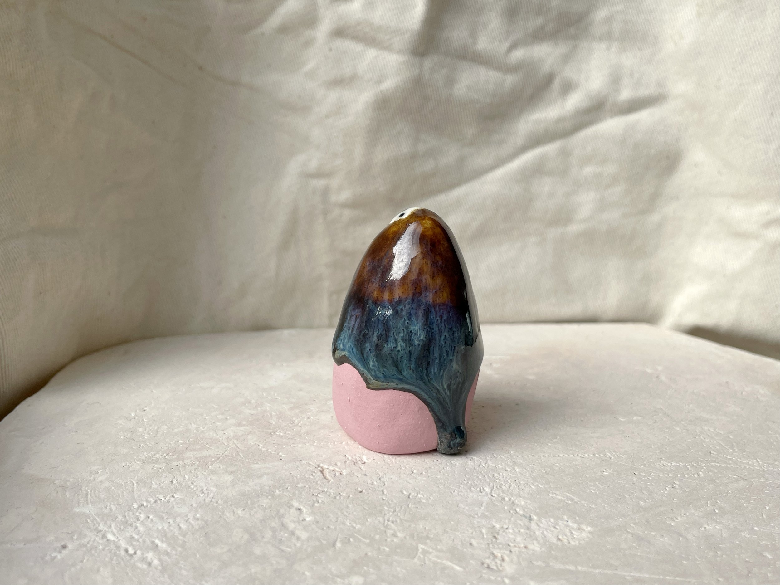 Brown, blue and pink handmade figurative ceramic sculpture with glossy drippy floating glaze
