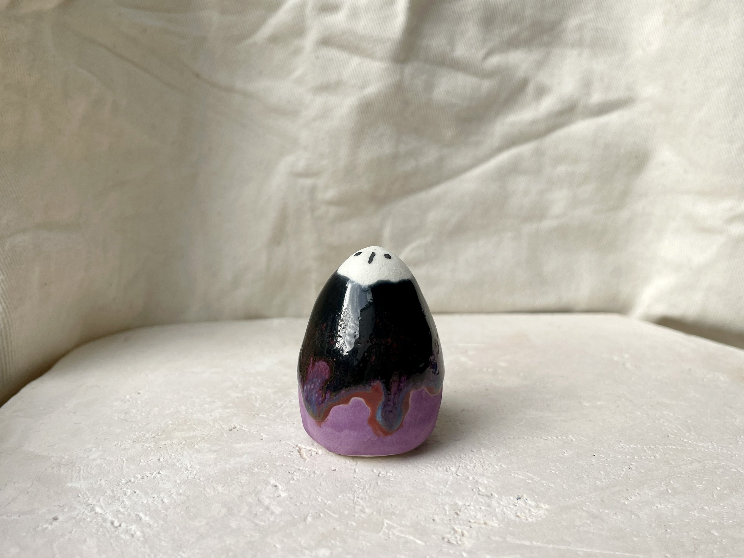 Purple, blue, red and black handmade figurative ceramic sculpture with glossy drippy floating glaze