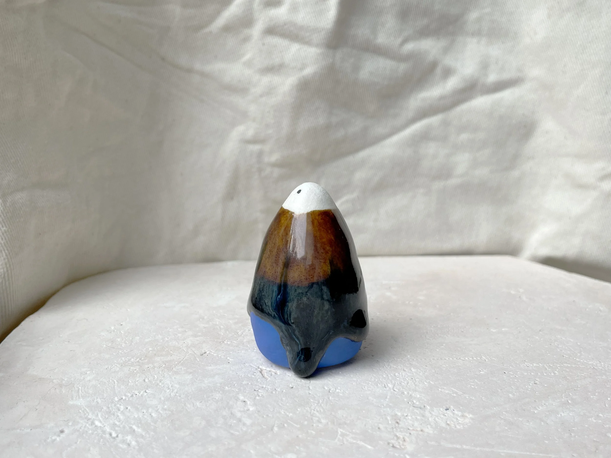 Blue, brown and black handmade figurative ceramic sculpture with runny drippy glaze