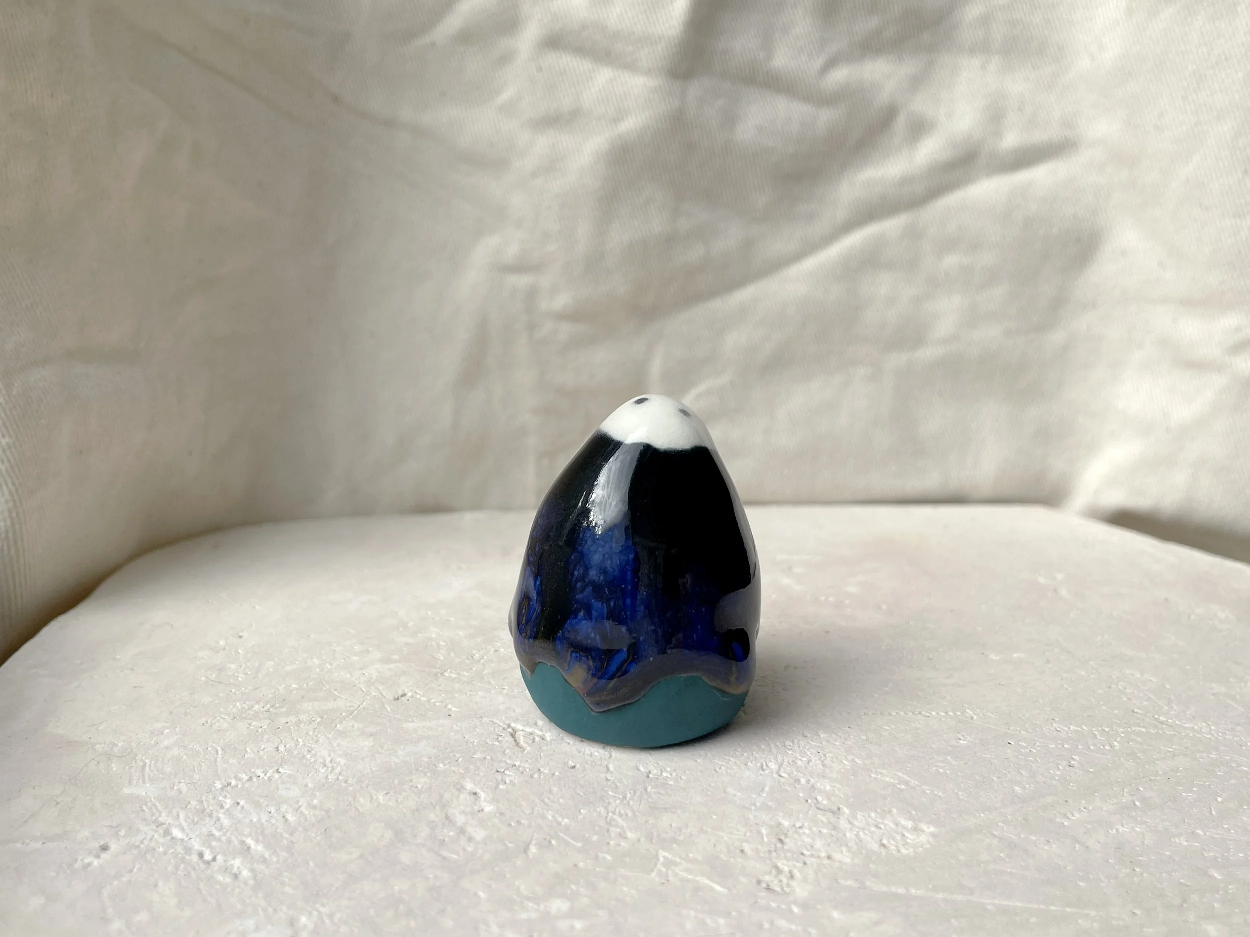 Black, blue and green handmade figurative ceramic sculpture with glossy drippy floating glaze