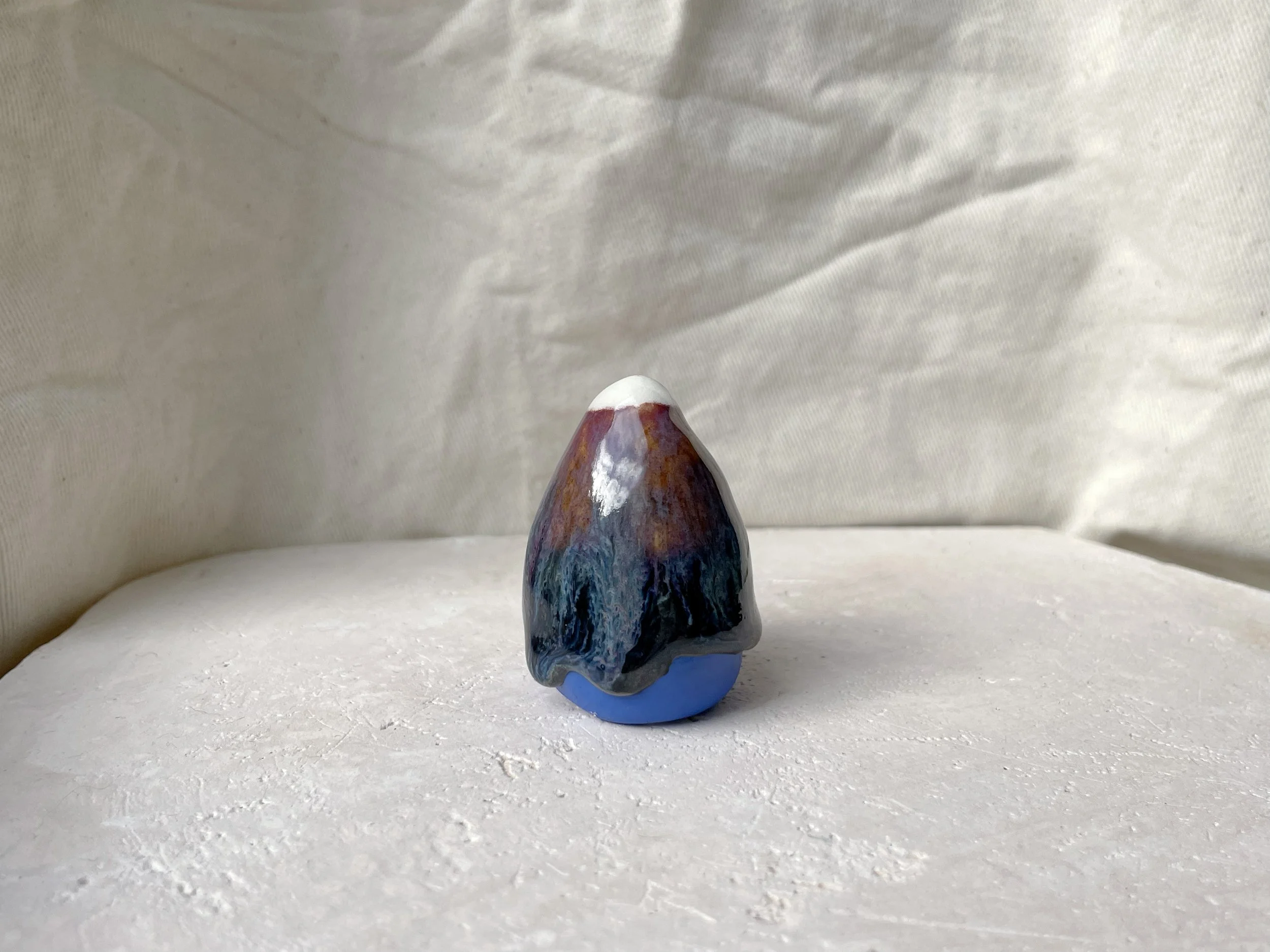 orange, purple, blue and black handmade figurative ceramic sculpture with glossy drippy floating glaze