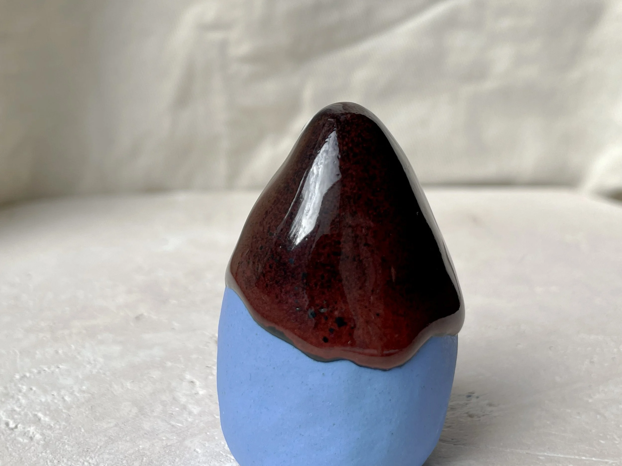 Blue, black and red handmade figurative ceramic sculpture with glossy drippy floating glaze