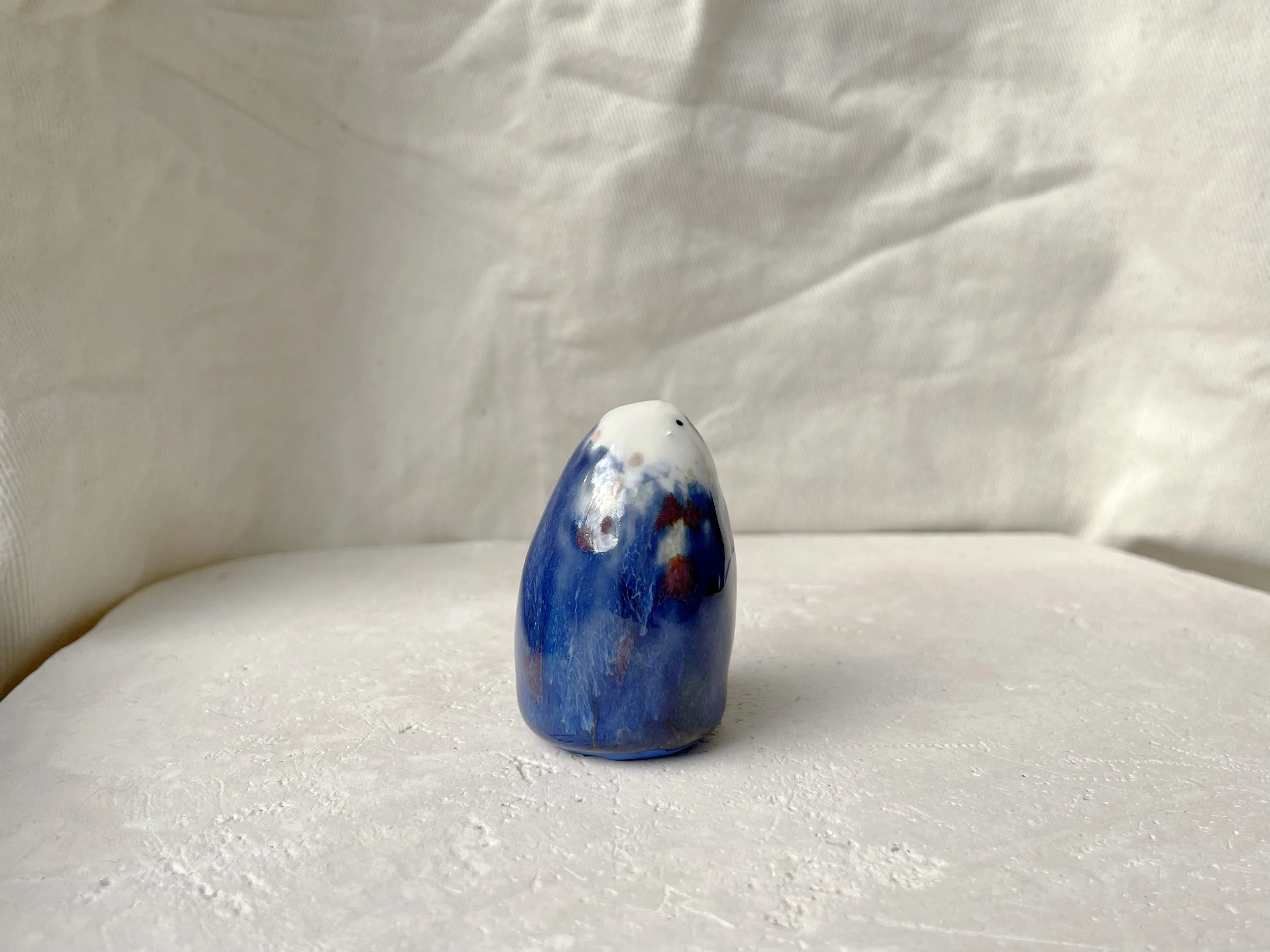 blue, white, red and pink handmade figurative ceramic sculpture with underglaze and glaze